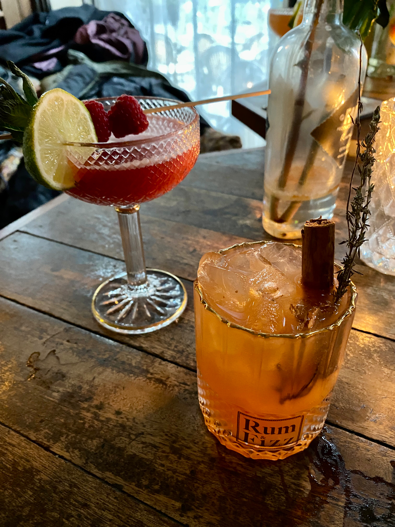Two cocktails on a wooden tabletop