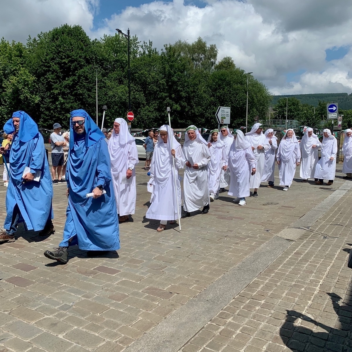 Procession of people in Druidic robes through a town centre