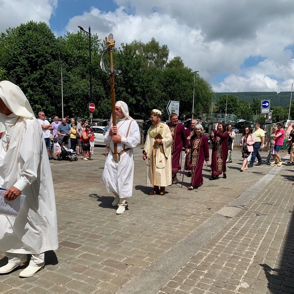 IProcession of people in Druidic robes through a town centre