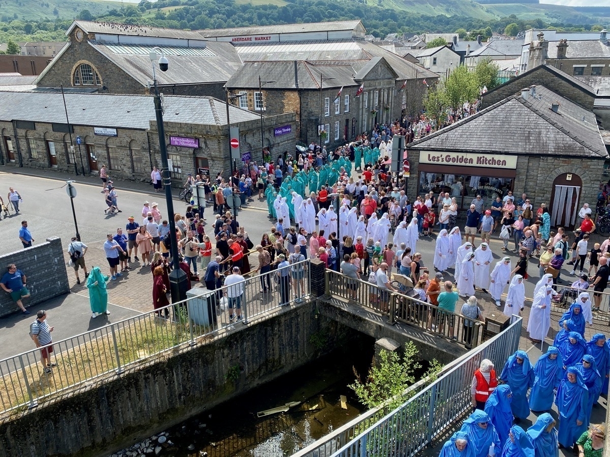 Procession of people in Druidic robes through a town centre