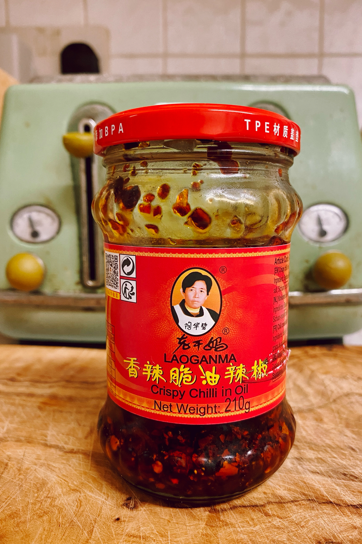 A jar of Lao Gan Ma Crispy Chilli in Oil on a kitchen counter.