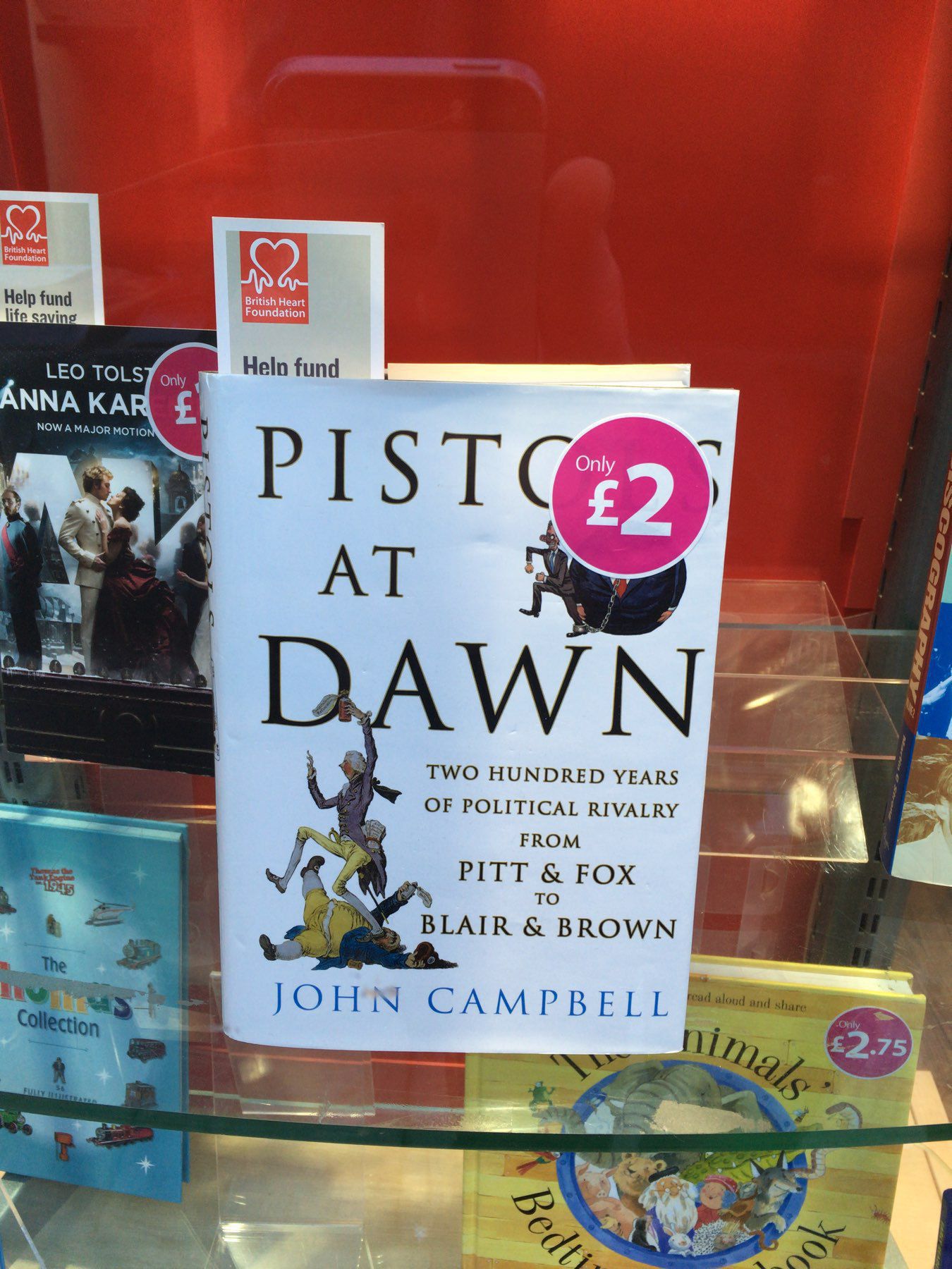 book in shop window, title partially covered by price sticker to read "Pist at dawn" i stead of "Pistols at dawn"