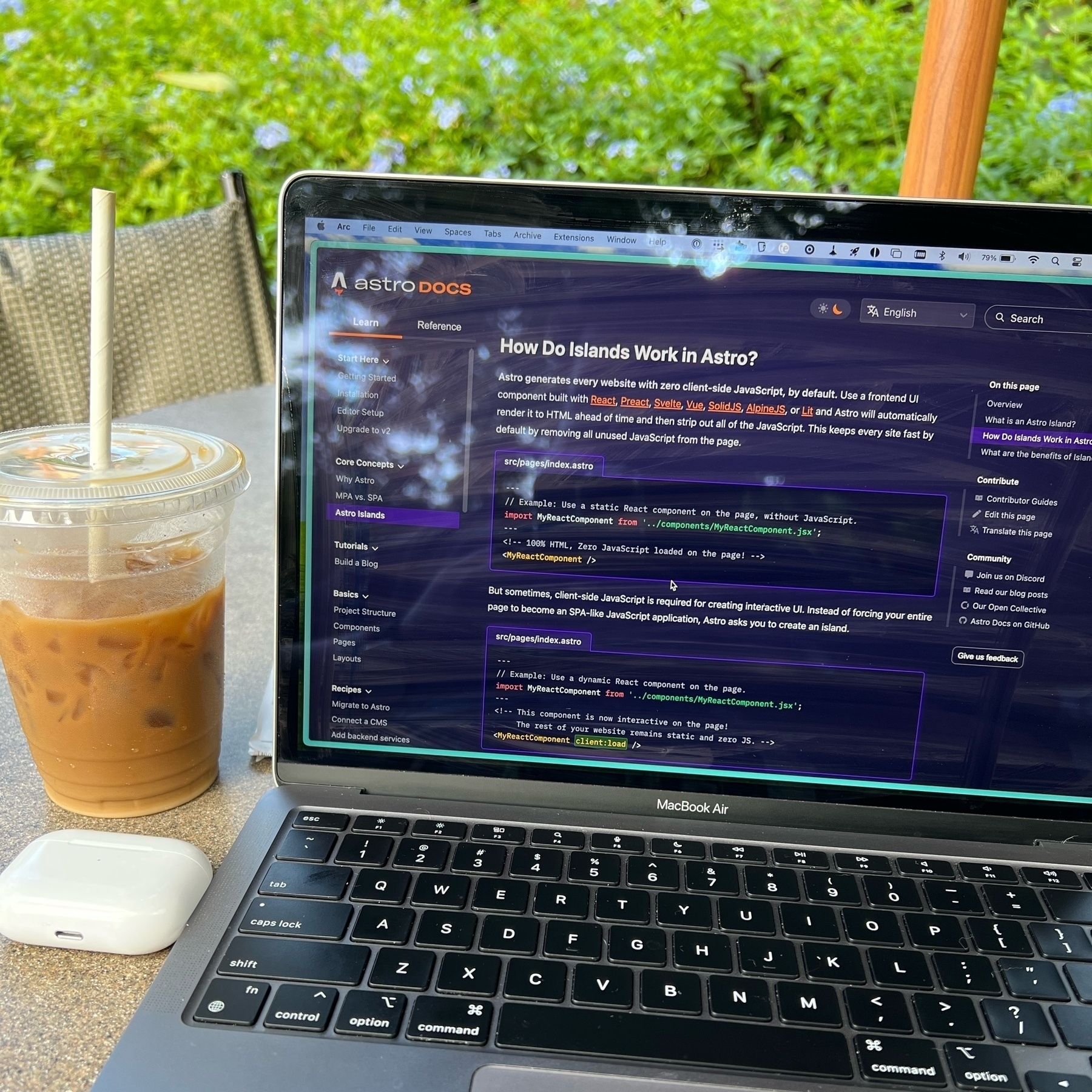 A cold brew, airpods, and a laptop on a table with Astro Islands docs on the screen