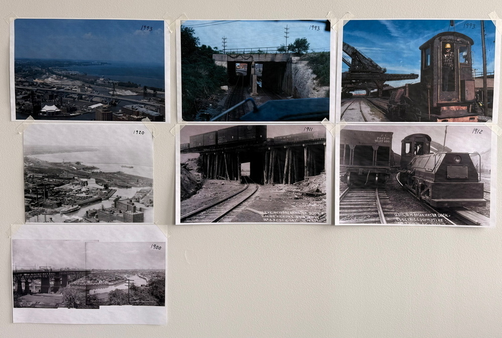 A collection of historical photographs depicting various scenes of railways and industrial landscapes is displayed on a wall.