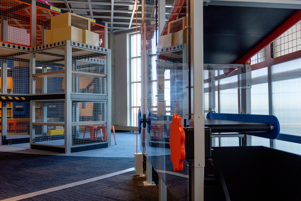 A modern indoor play area featuring climbing structures, slides, and safety nets is visible.