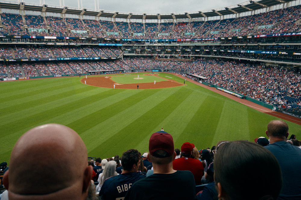 A crowded baseball stadium is filled with spectators watching a game in progress on a well-maintained field.