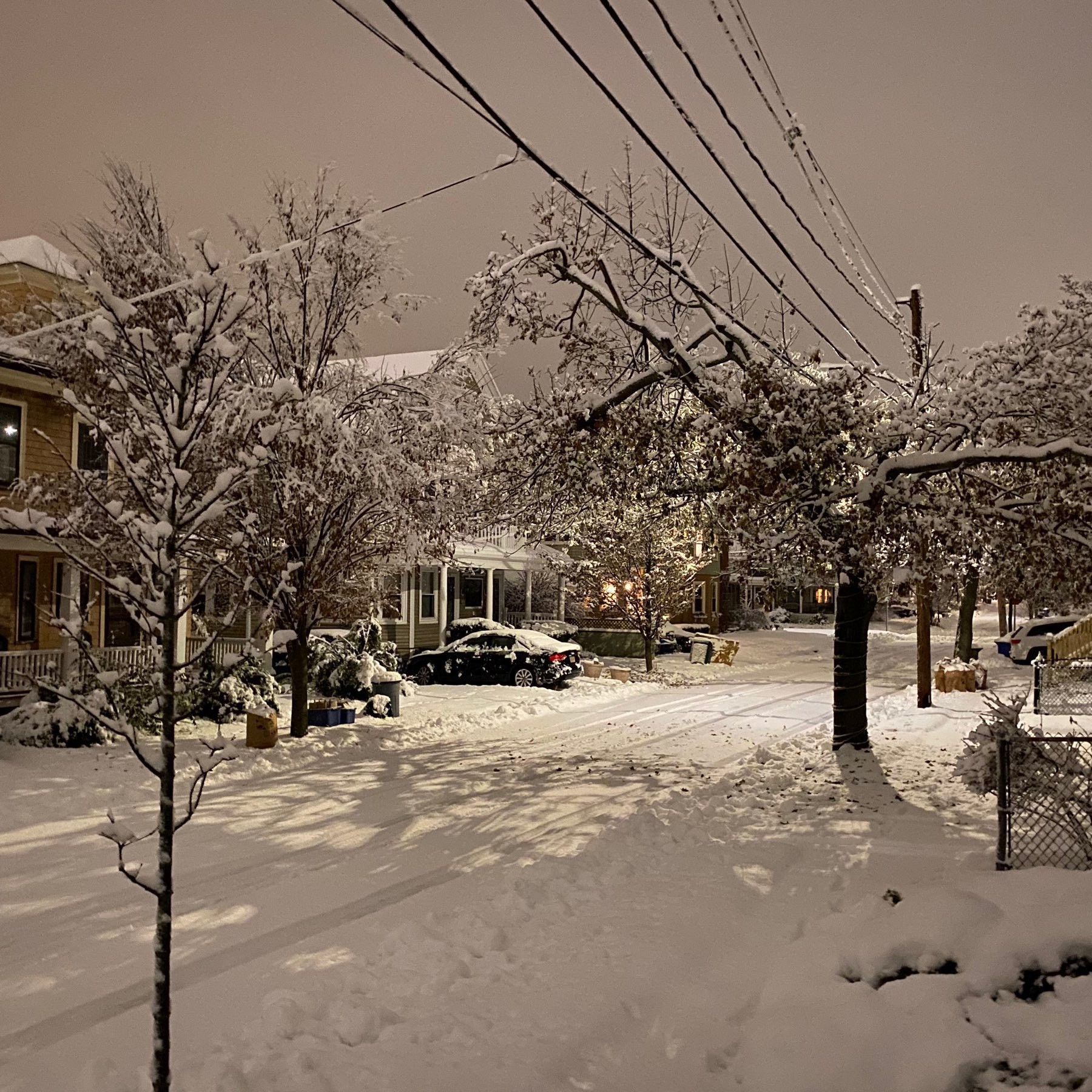 snow covered street with houses and powerlinea