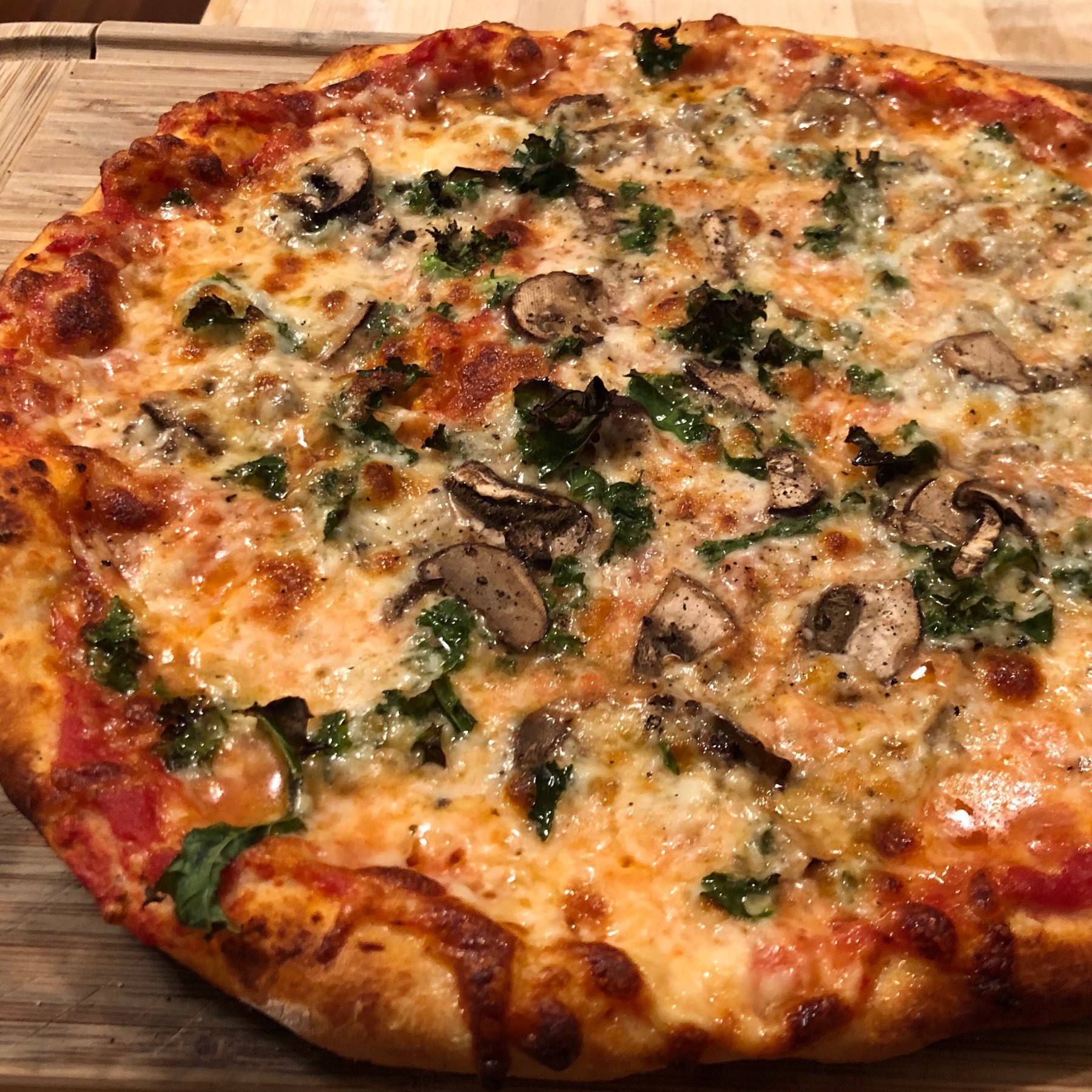 Close up on kale and mushroom pizza.