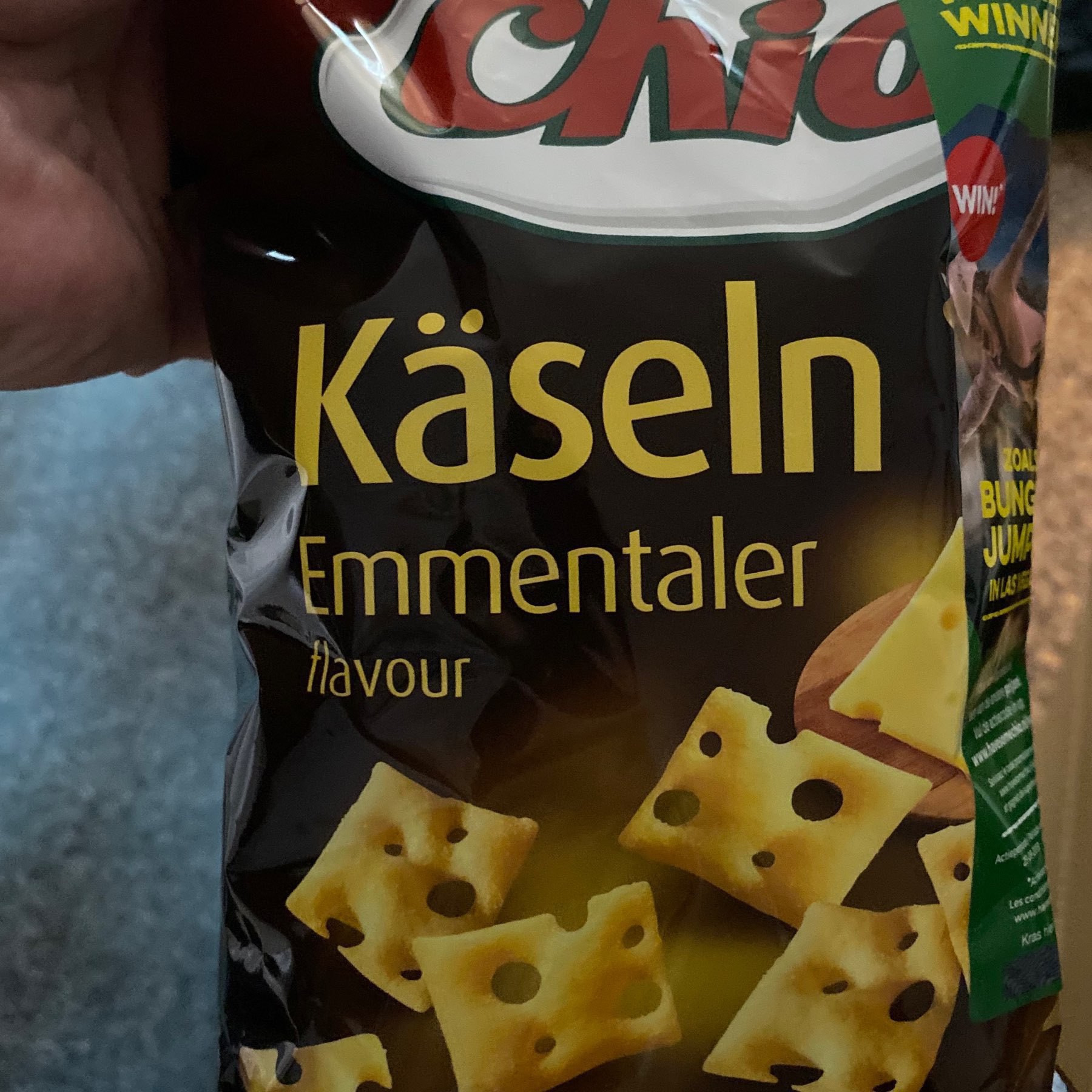 Picture of a snack bag with "Käselin Emmentaller" descriotion and crackers with swiss-cheese wtule holes.