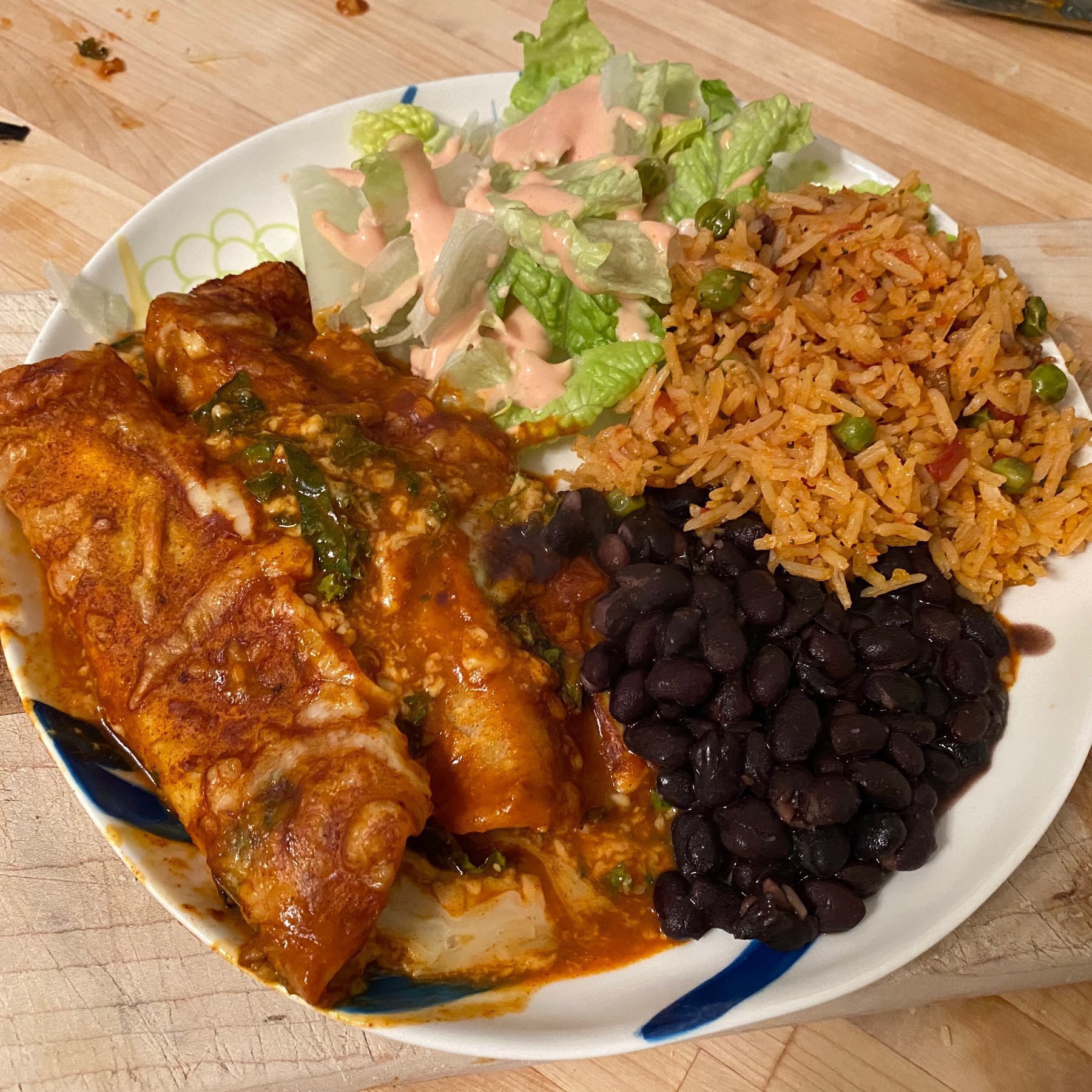 plate with kale enchiladas, beans and rice