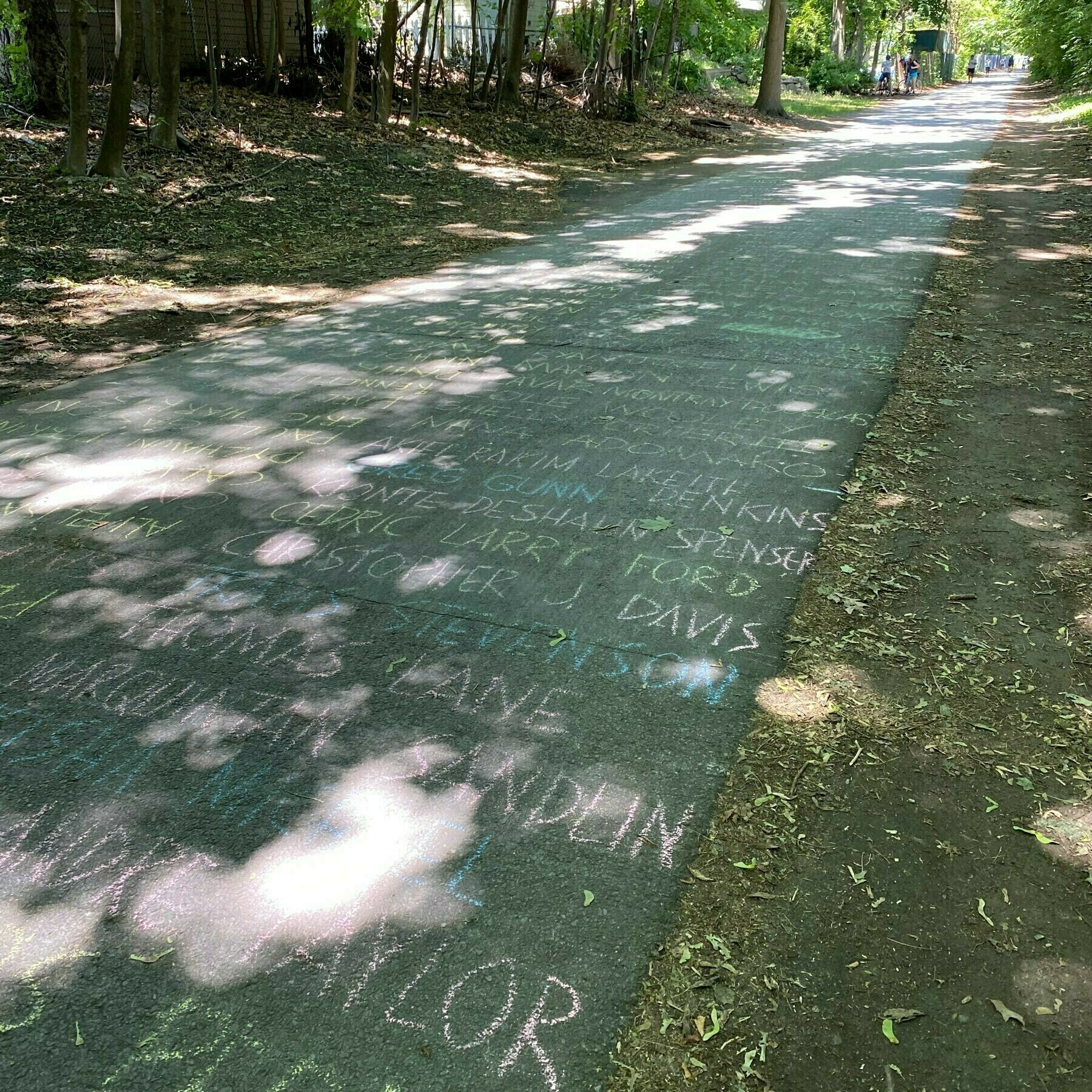 photo of a paved bikeway with names written in chalk 