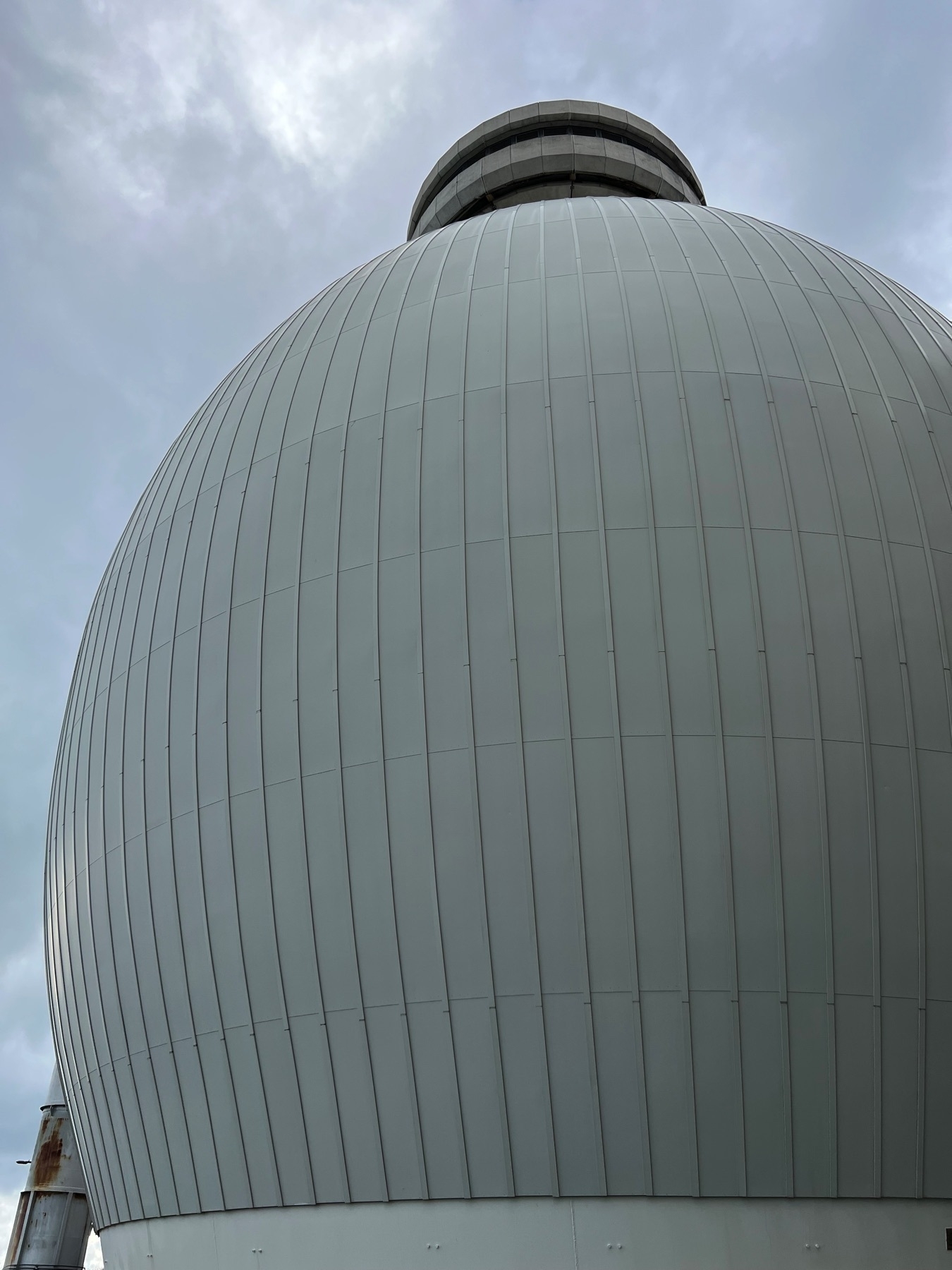 a huge, bulbous structure with ribbed metallic exterior