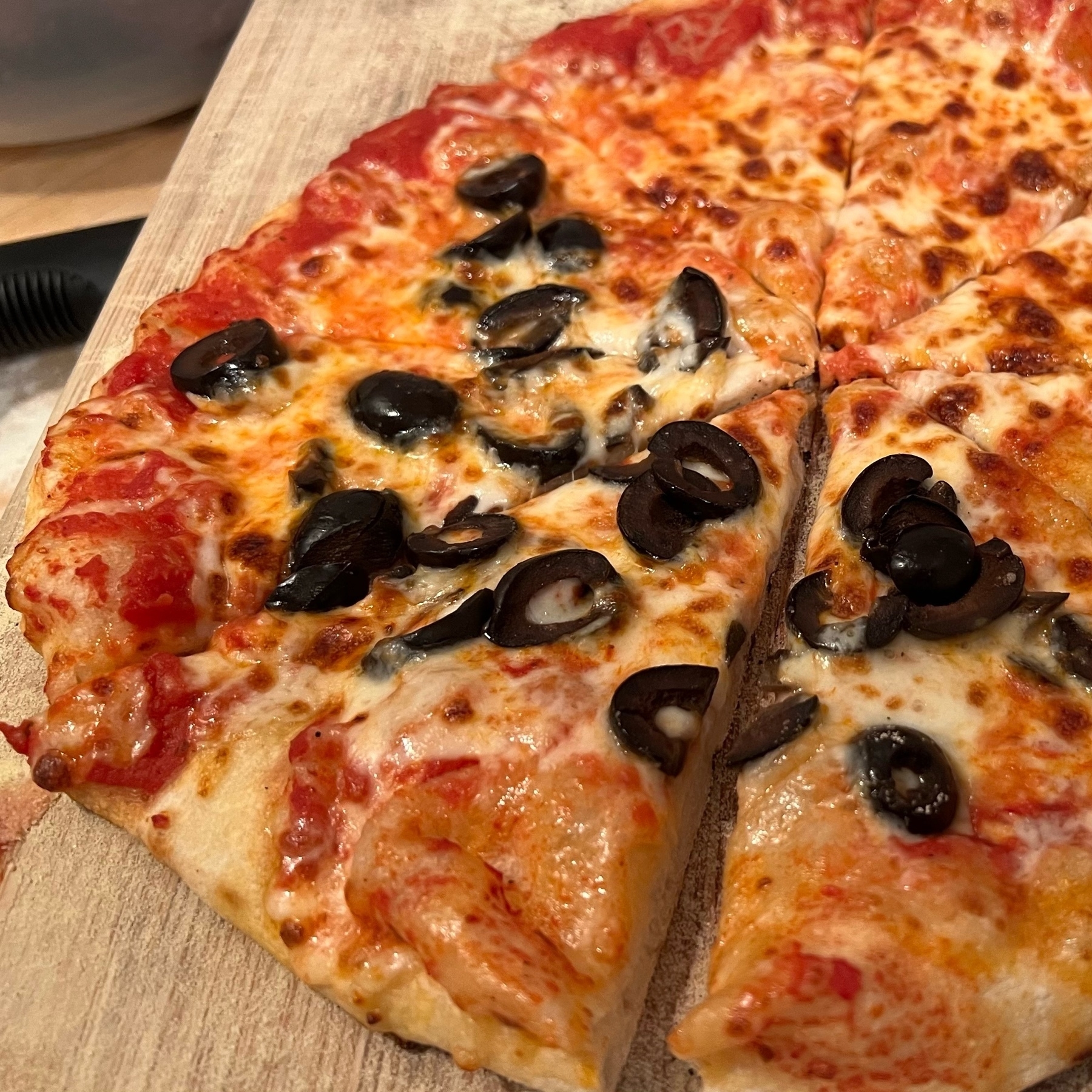 Homemade pizza with puffy crust and black olives