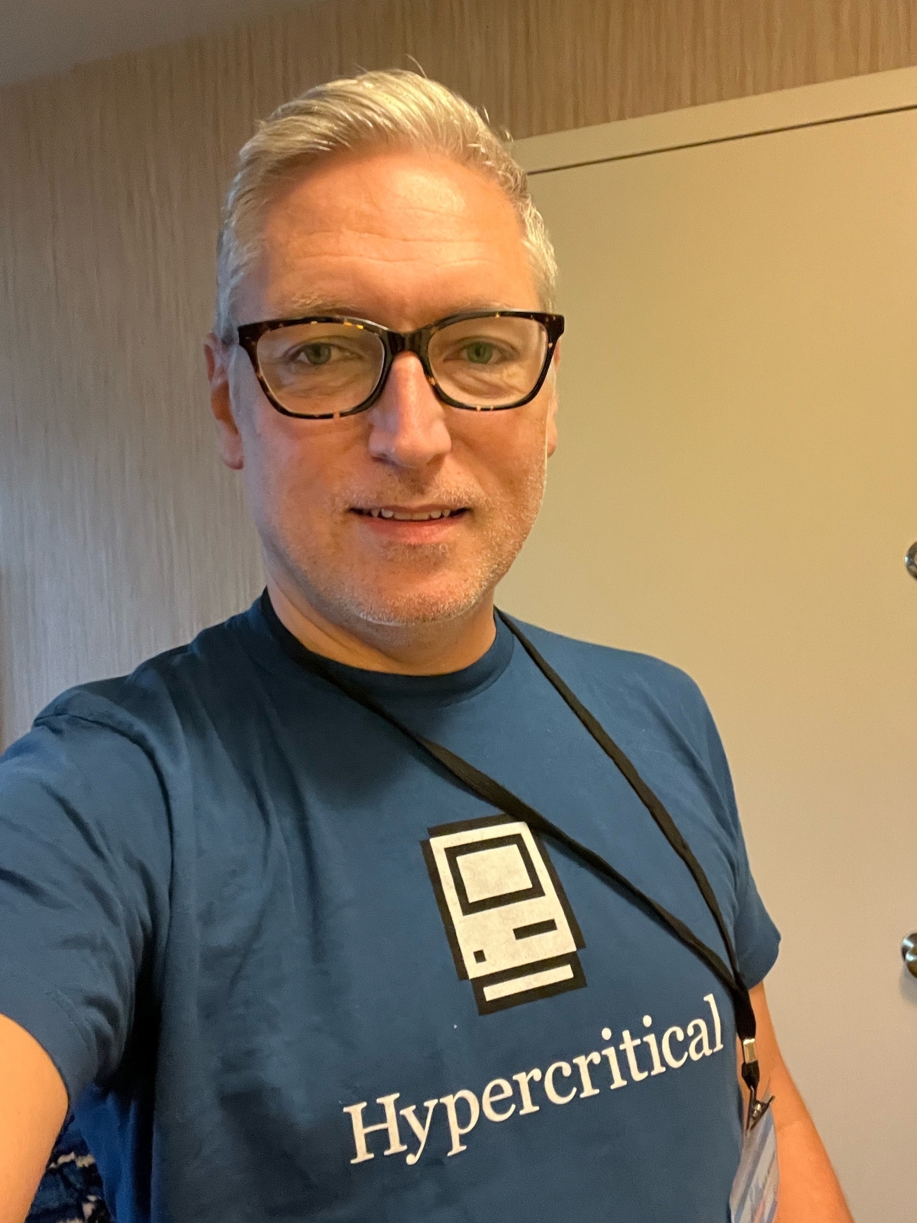 Selfie of white man with gray hair wearing a blue “Hypercritical” tee shirt with classic Mac icon.