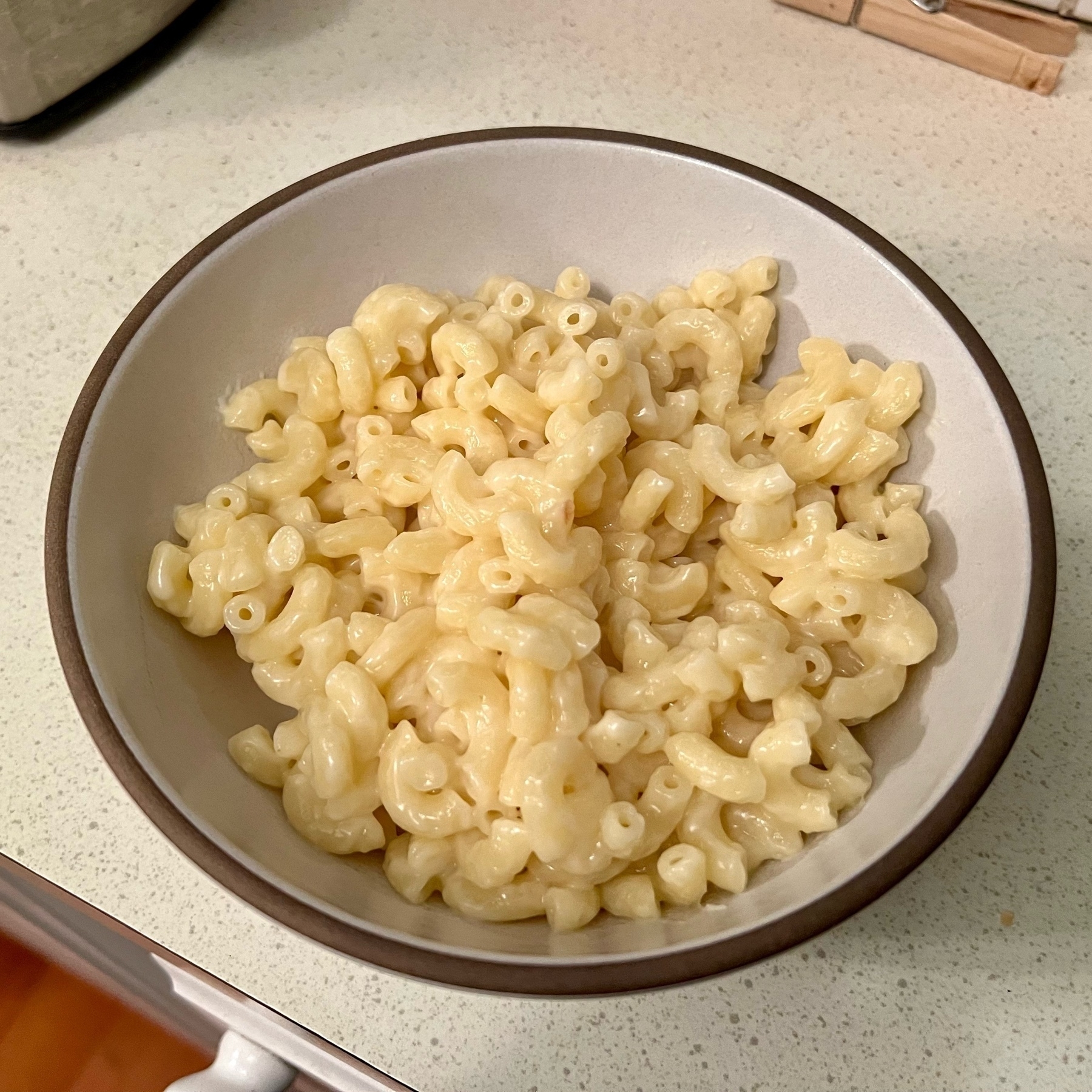 ceramic bowl filled with elbow macaroni pasta coated in white cheese sauce