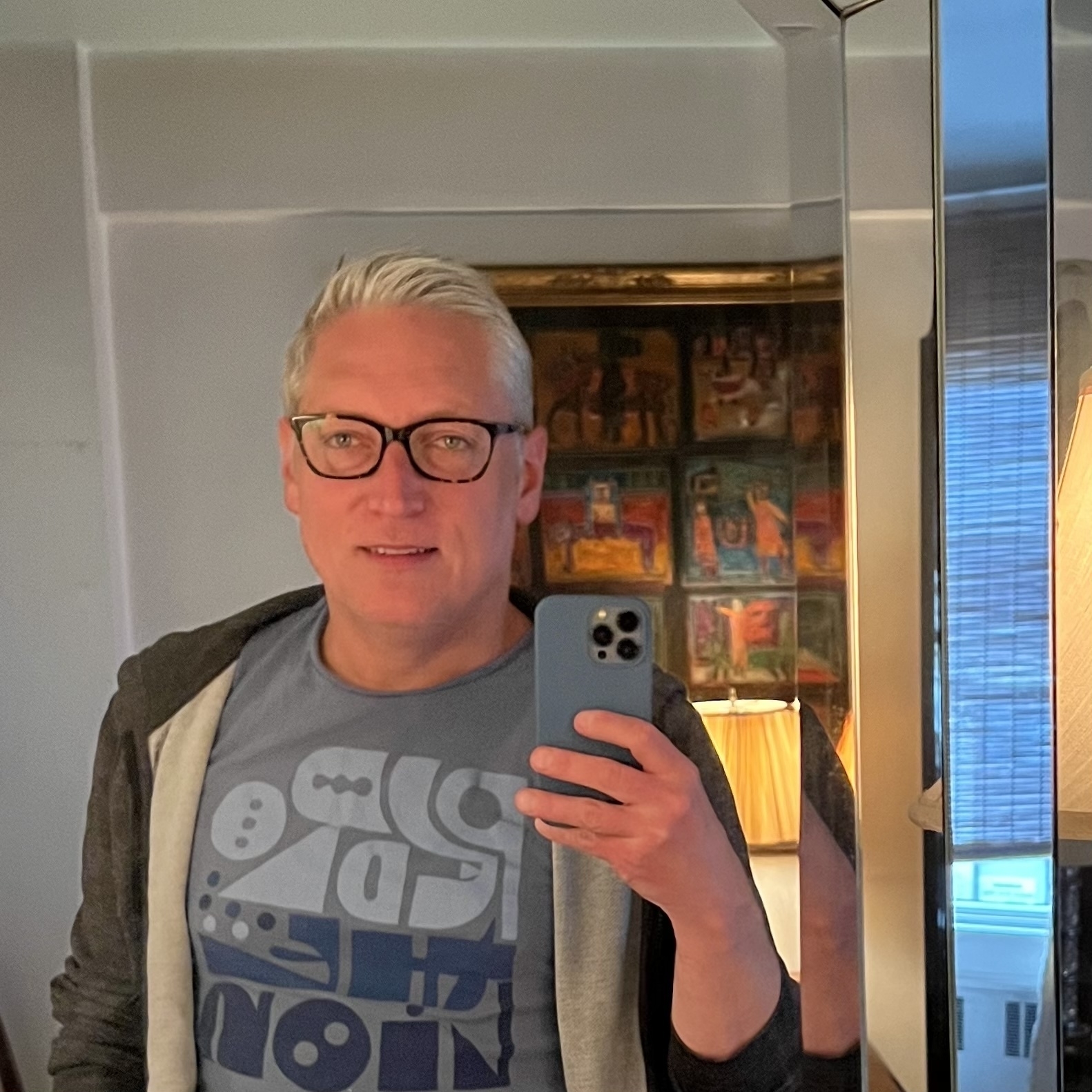 selfie in a t-shirt and sweatshirt, skilijg, grey hair, mirror edge showijg vertical distortions at eight edge