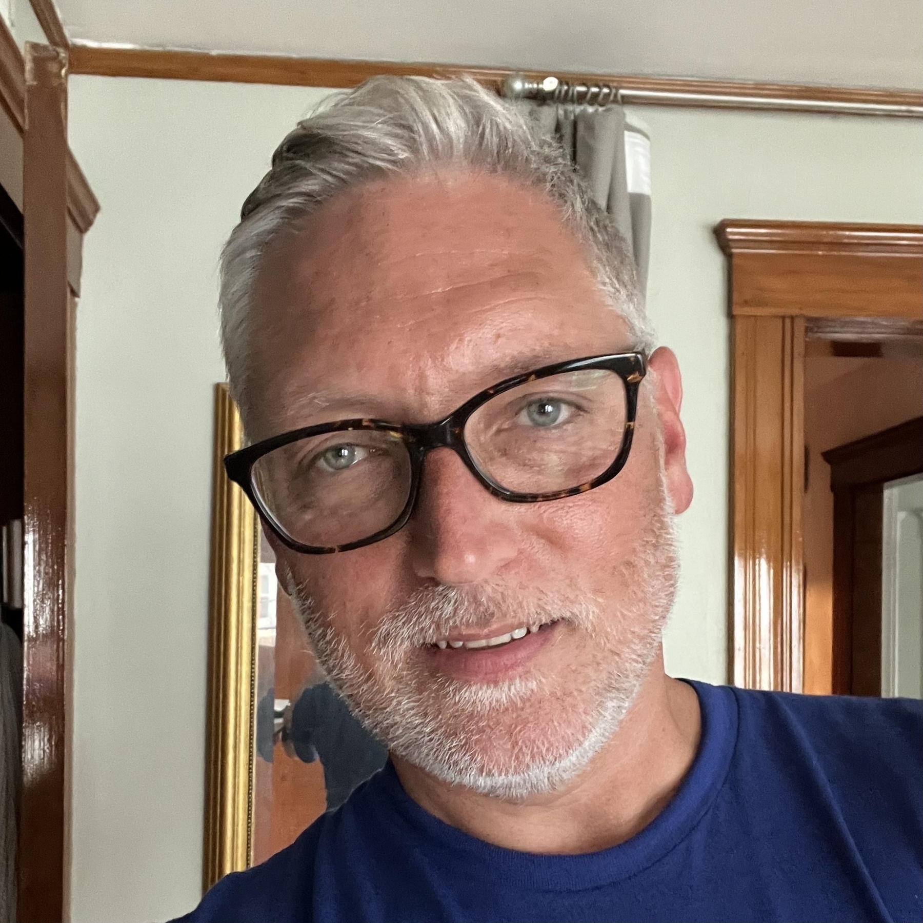 Selfie of a Caucasian man with tan skin and white/grey heart with white stubble. 