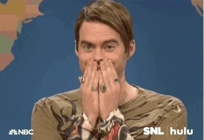 Stefan character from SNL, looking into the camera with an embarrassed look and his hands cupping his mouth.