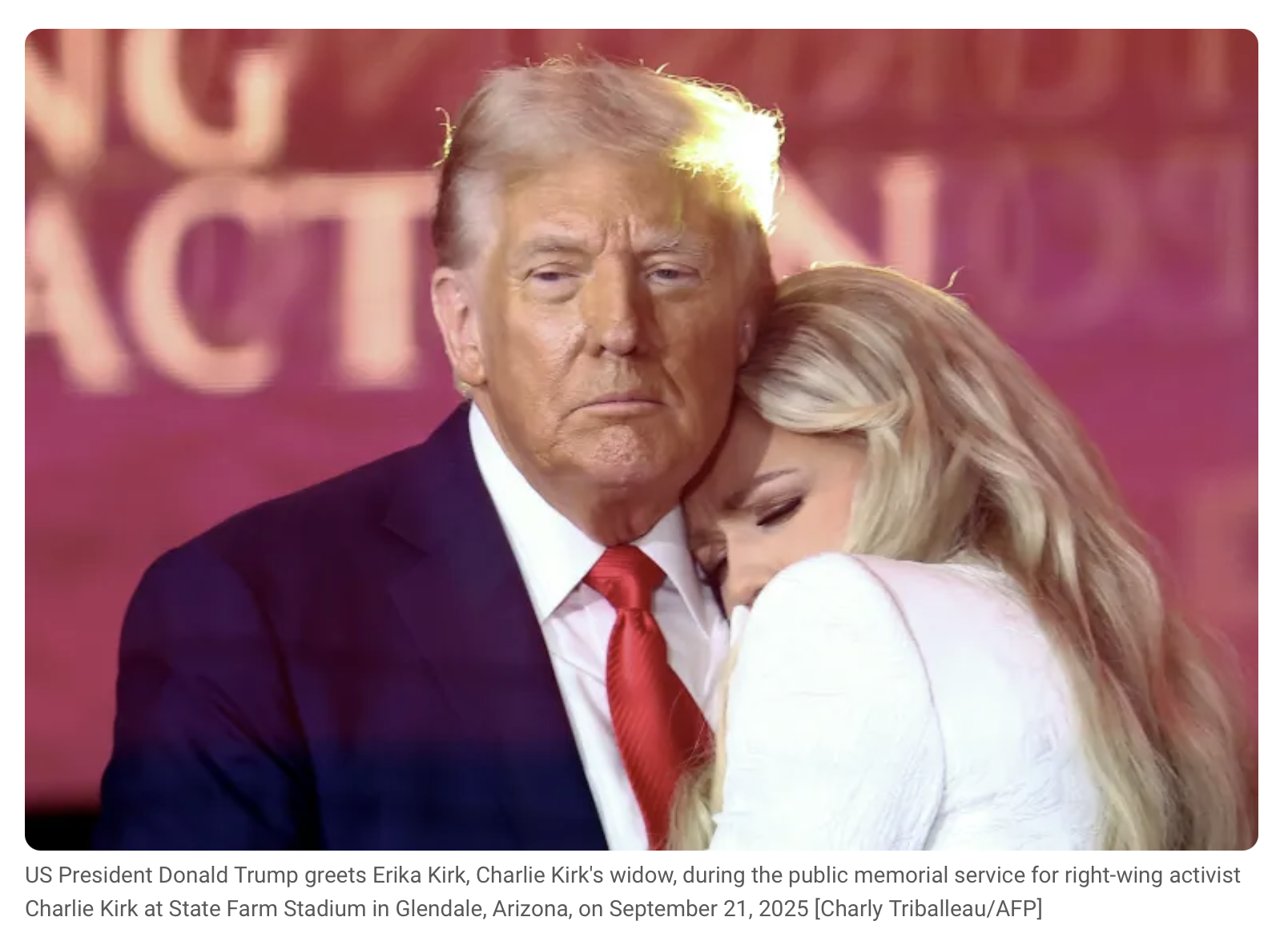 Picture featuring President Donlad Trump looking forward with Erika Kirk leaning into his side, nestling against his neck.