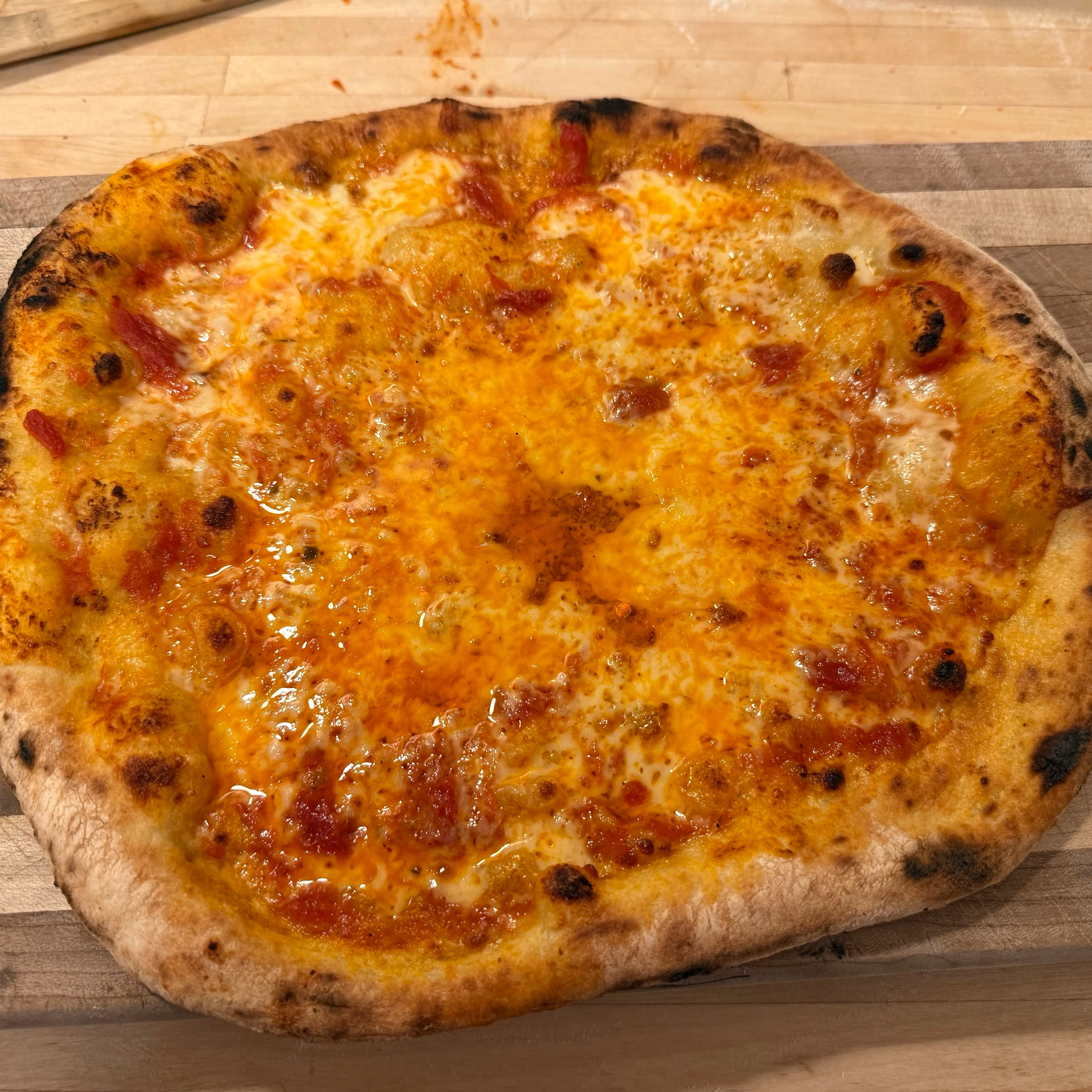 Home baked cheese pizza with puffy, charred crust.