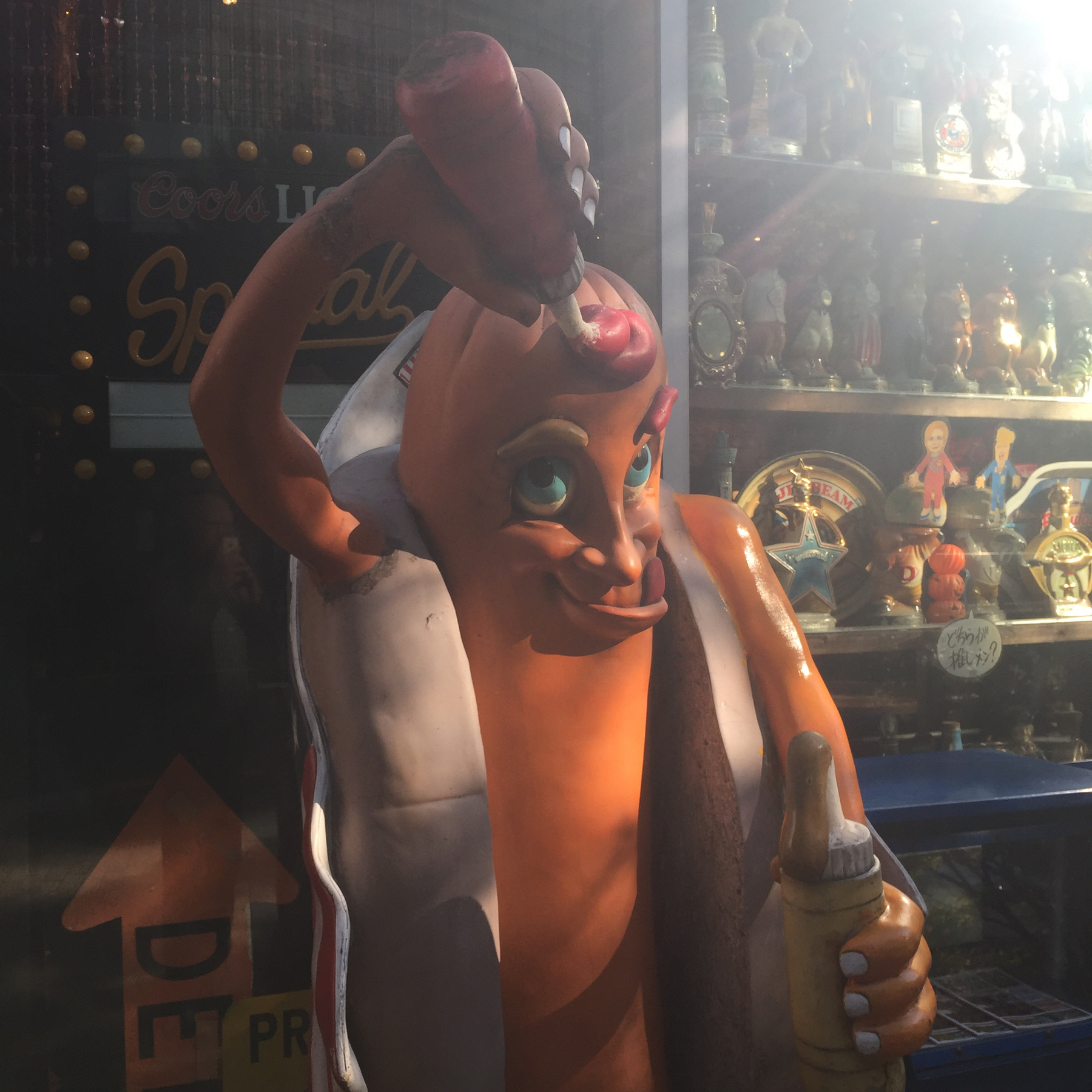 Kitschy hotdog mascot dousing itself with ketchup 