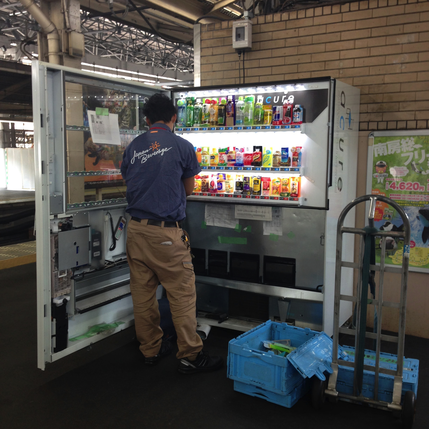 Photo of worker refilling a vending machine on the train platform 