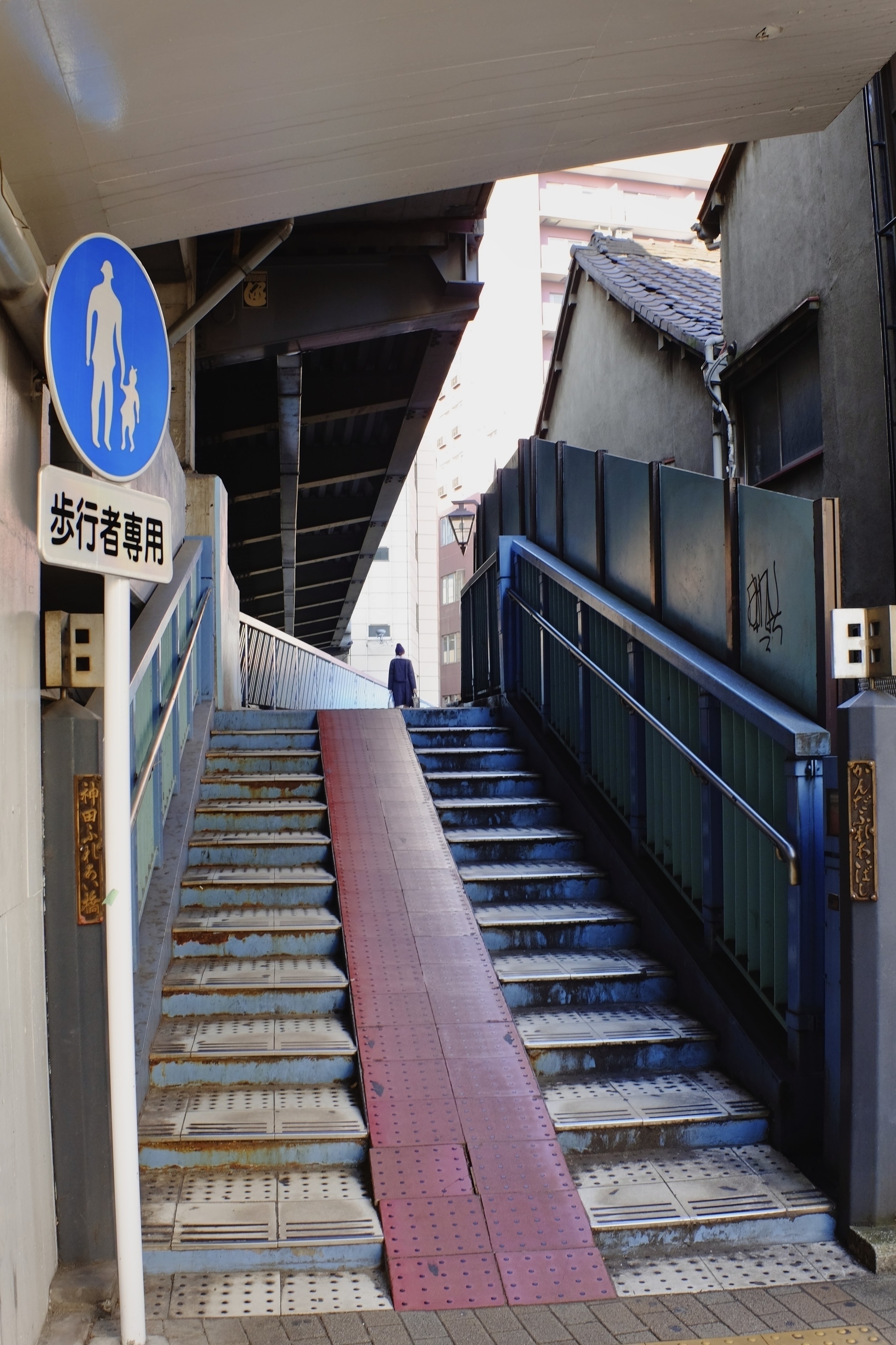 Pedestrian bridge with red tiled access ramp in Kanda Tokyo. 