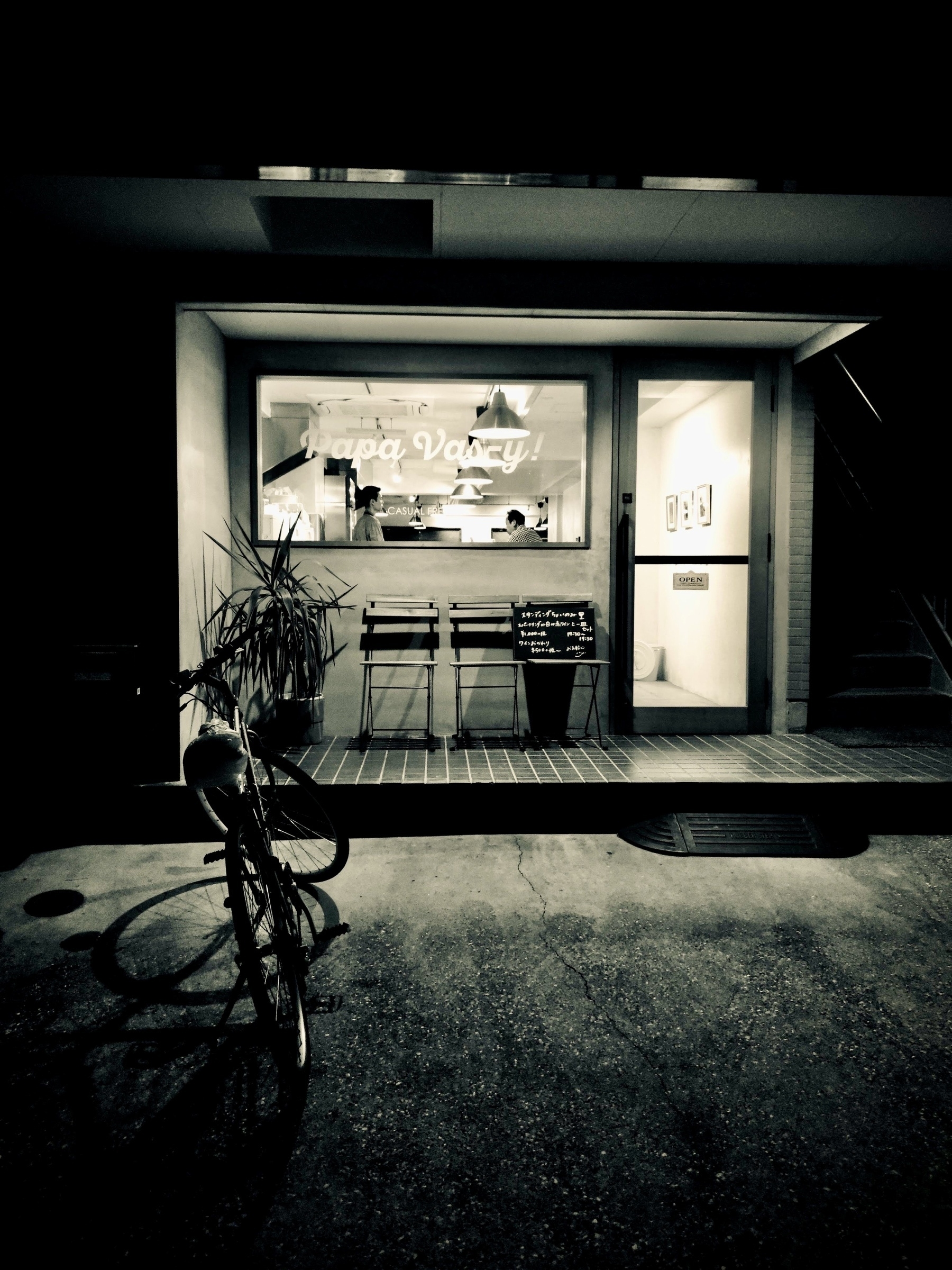 Night view of the store front of the “Papa Vasy” casual French restaurant in Totsuka, with bicycle parked in front. 