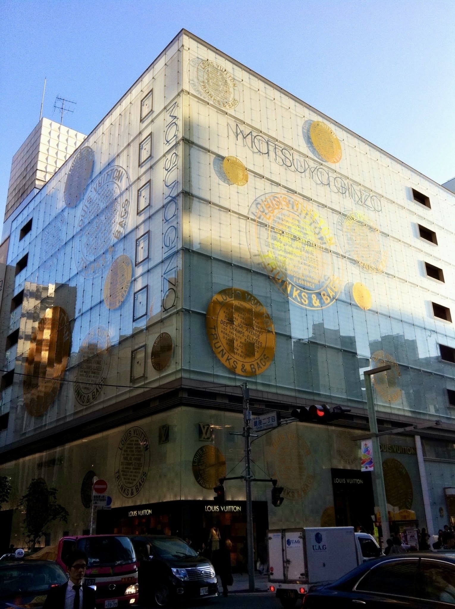 A high end department store’s exterior is decorated with a luxury brand’s name and logo. 