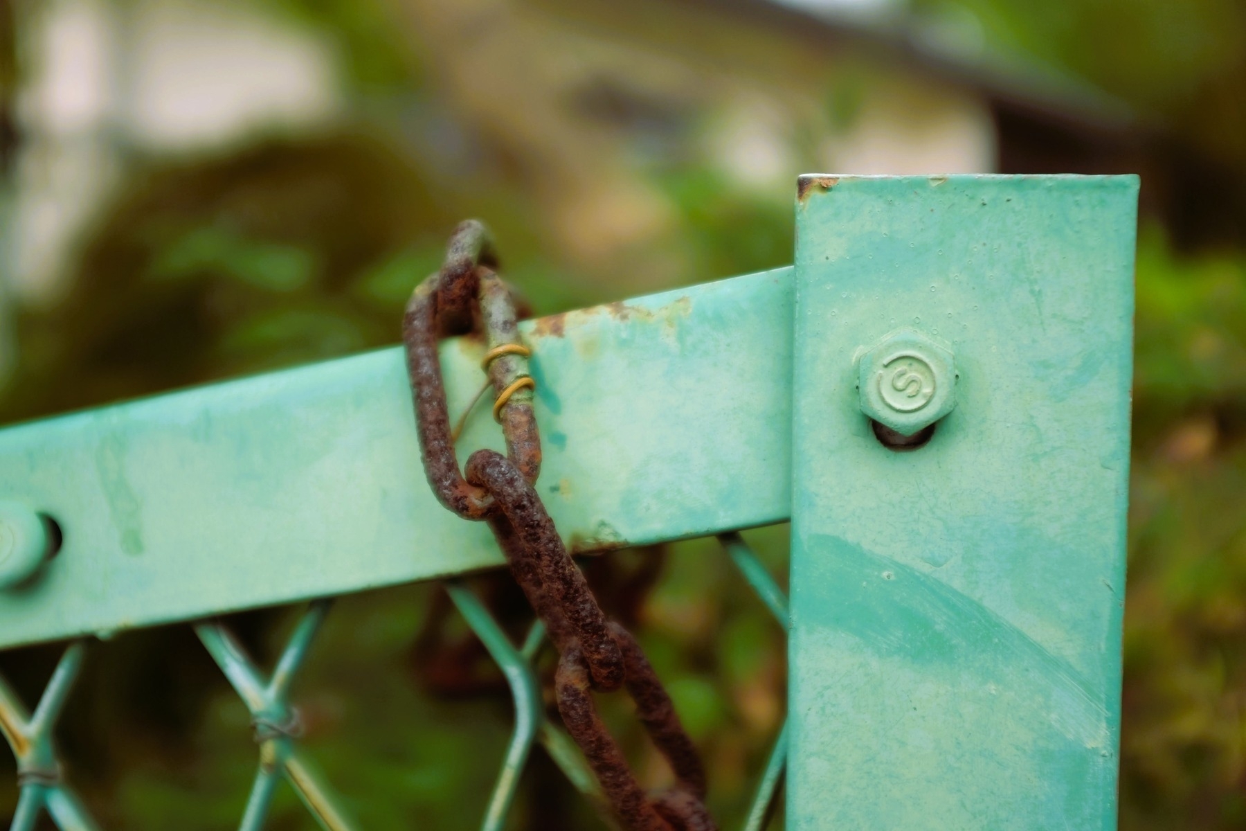 Photo of painted fence with rusty chain