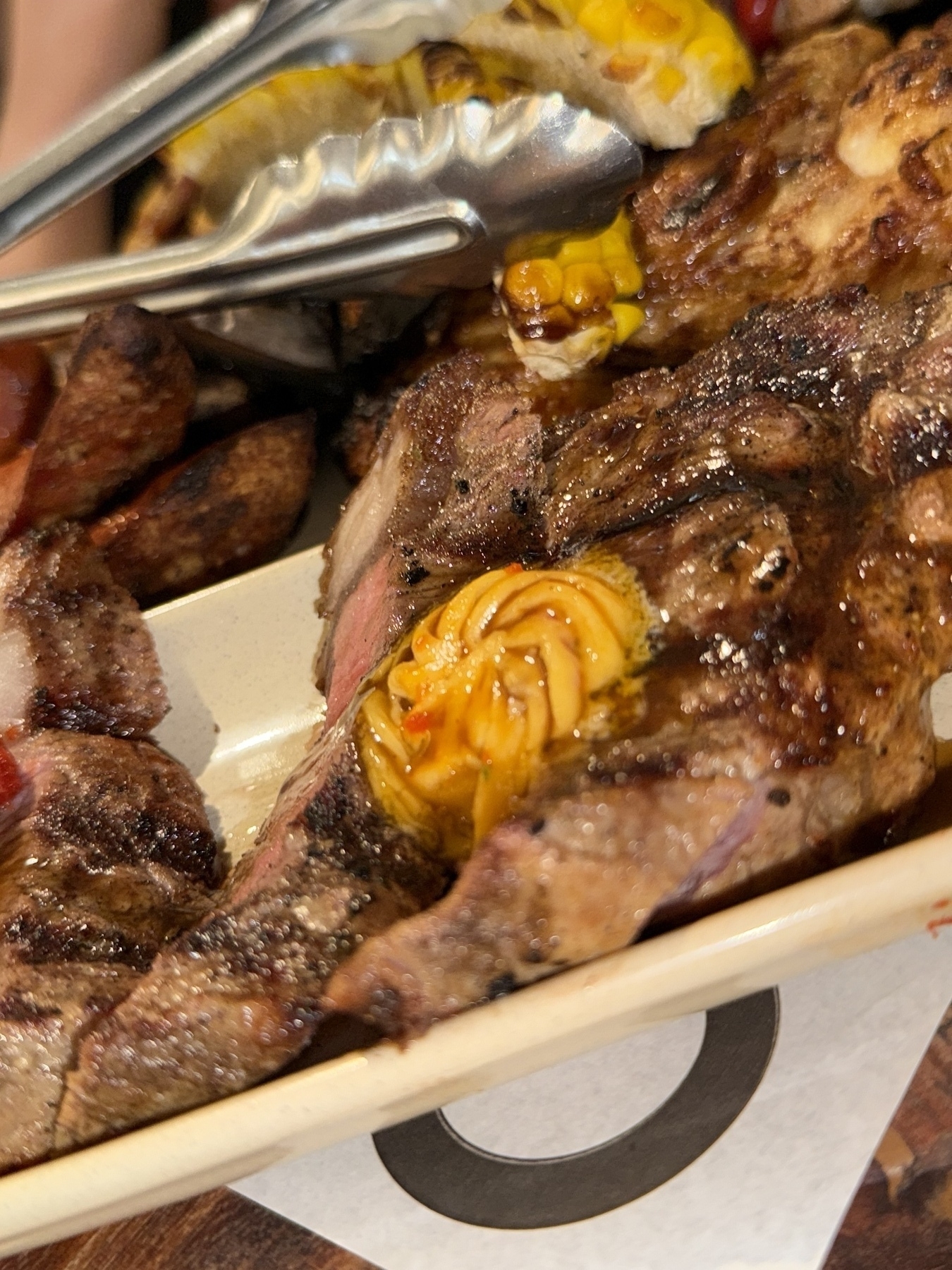 Close up of steak on a meat platter with a butter on top