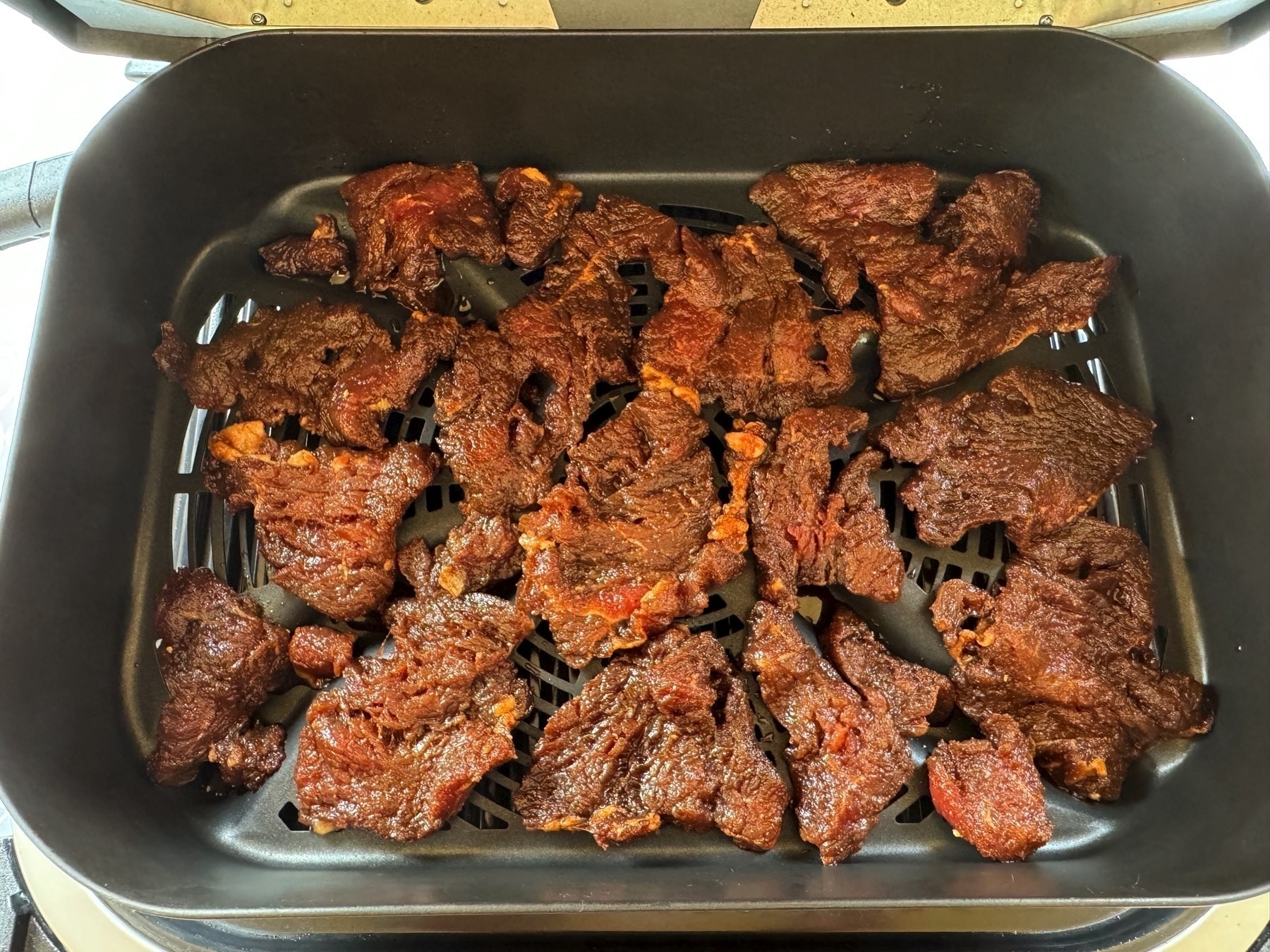 marinated beef in a tray waiting to be slowly dehydrated to become jerky.
