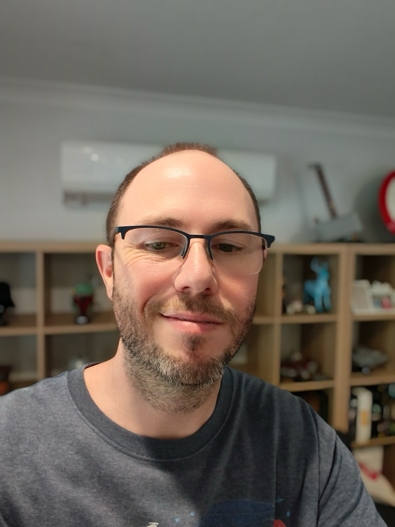 selfie in front of some shelves and an air conditioner