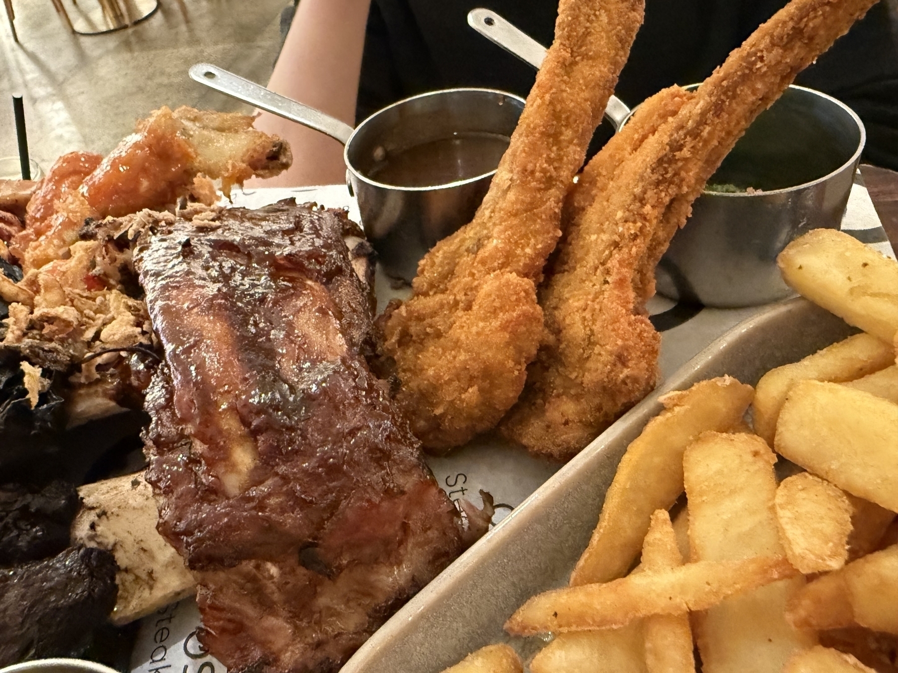 Crumbed lamb cutlets, pork ribs and chips on a meat platter