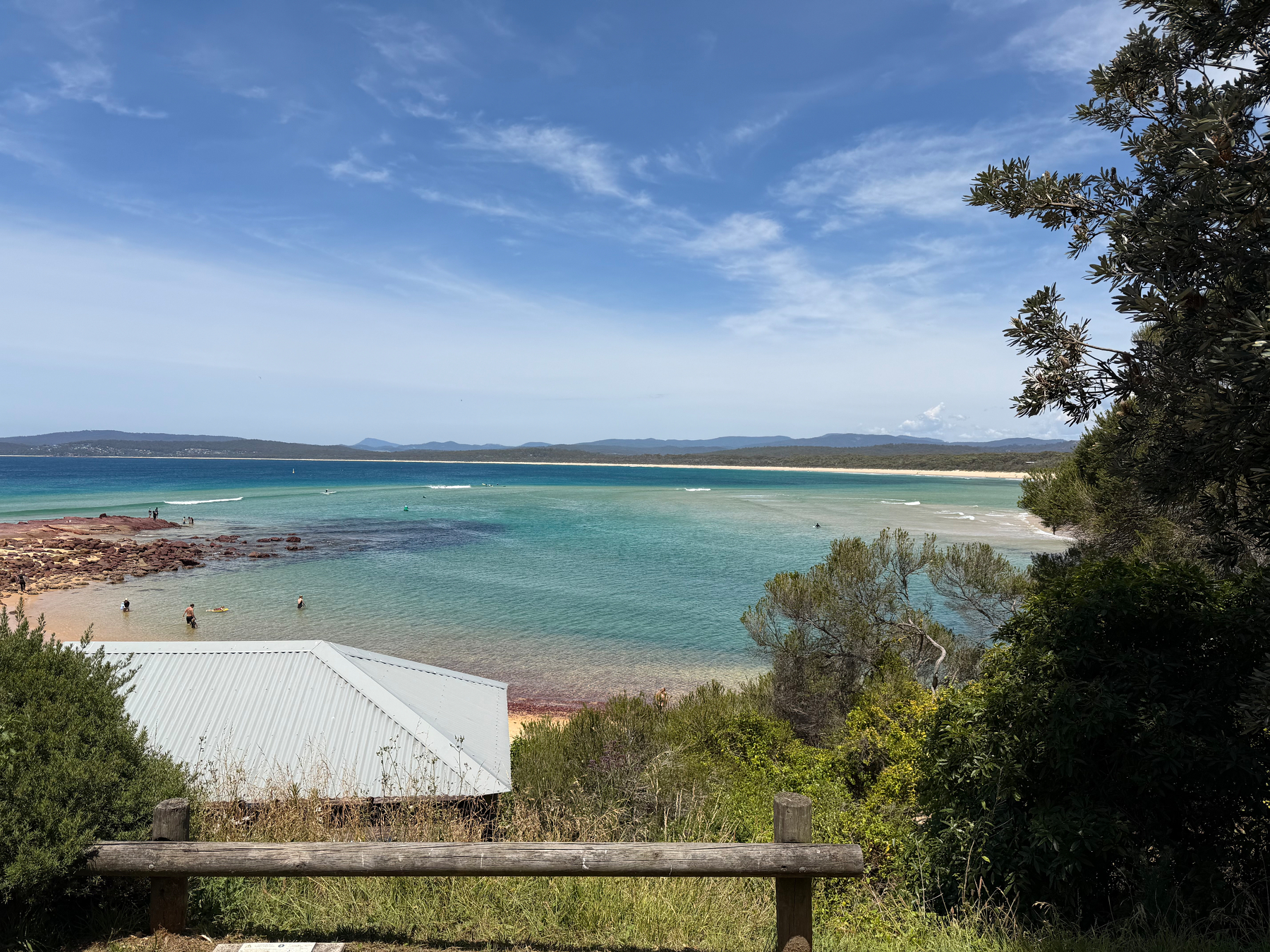 A sunny day overlooking the beautiful blue waters of a beach. 