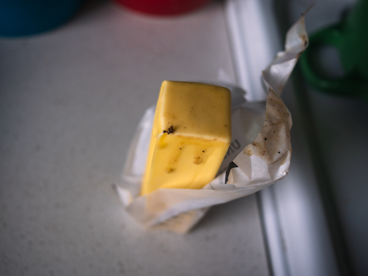 A photograph of a stick of butter, partly melted on the end