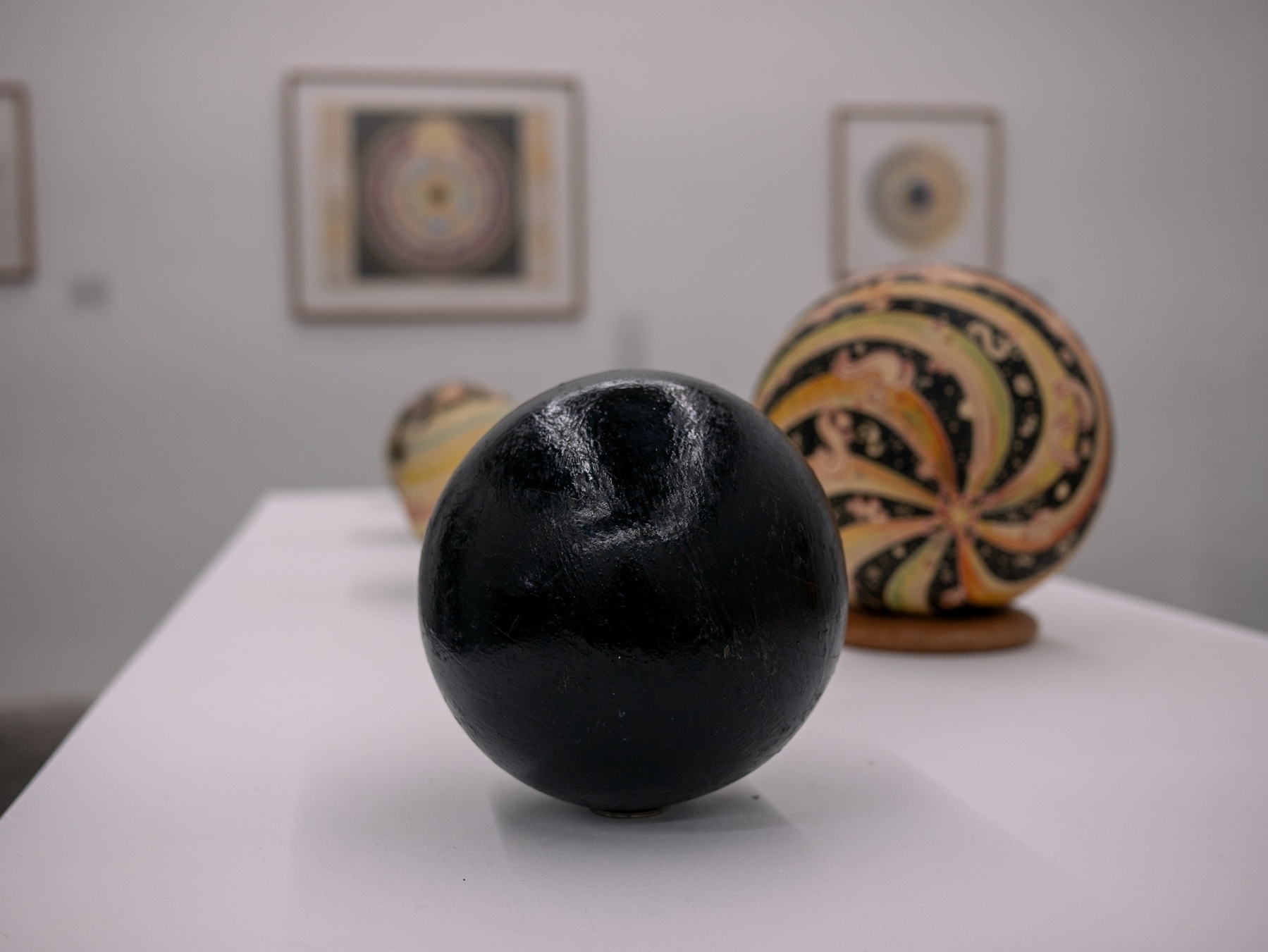 A series of painted spheres, with the one in the foreground painted solid black