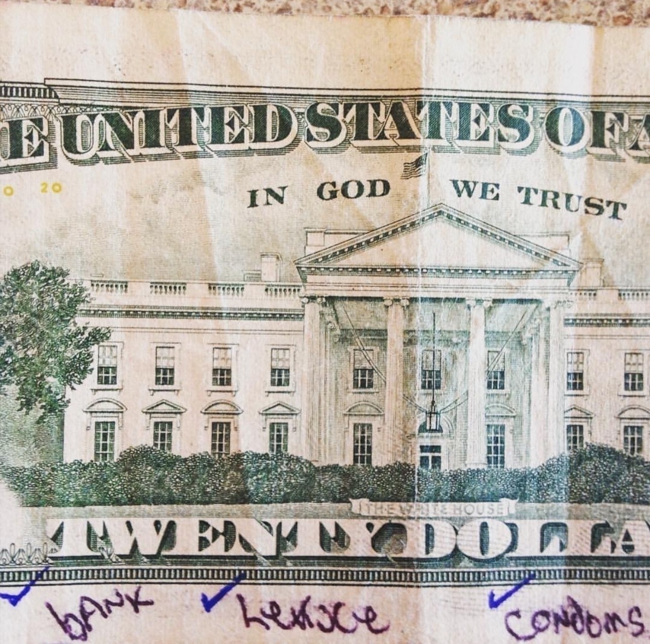 a photo of the back of a twenty dollar bill with a shopping list: bank, lettuce, condoms