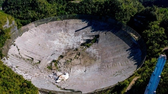 A photo of the Arecibo Radio Telescope after the tower collapsed.