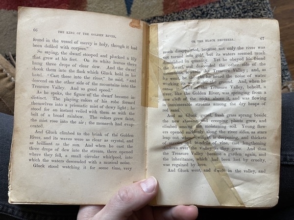 A photo of two pages of a book, one which has been repaired with yellowing tape