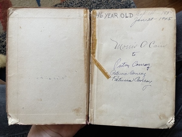 A photo of the inside front cover of a book, with names inscribed and the text "46 YEAR OLD" written in pencil