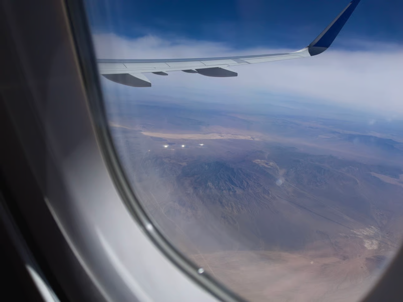 IMG_5903.jpeg.png A photo taken through an airplane window showing the California desert and three white glowing orbs in the distance