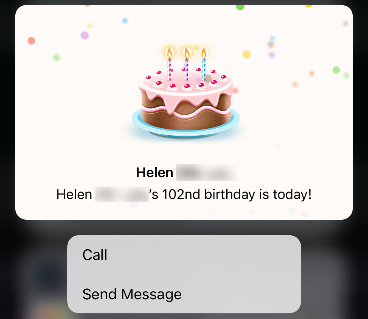 A graphic birthday cake with three candles implying a notification about someone's 102nd birthday; options to call or send a message below. Text: 'Helen [surname redacted]s 102nd birthday is today!'