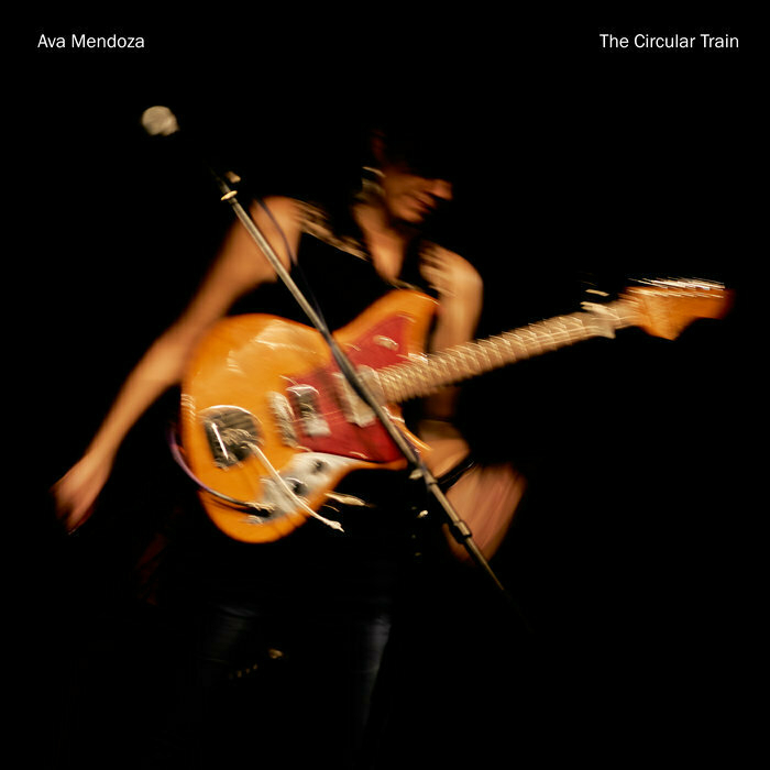 Cover image for Ava Mendoza's album The Circular Train, showing a slightly blurry Mendoza on stage with an orange and red Fender Jazzmaster guitar