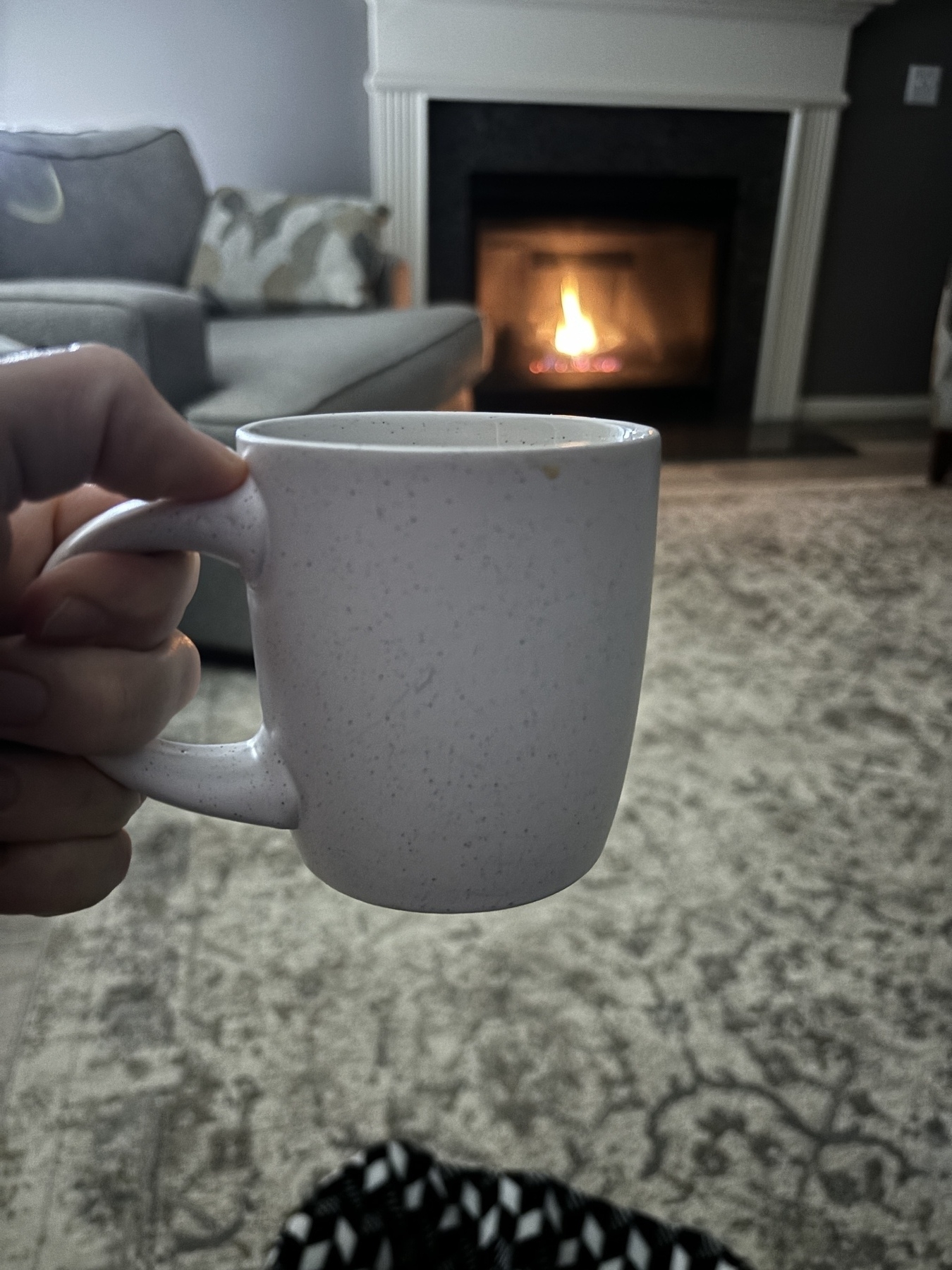A white coffee mug in front of an inviting fire 