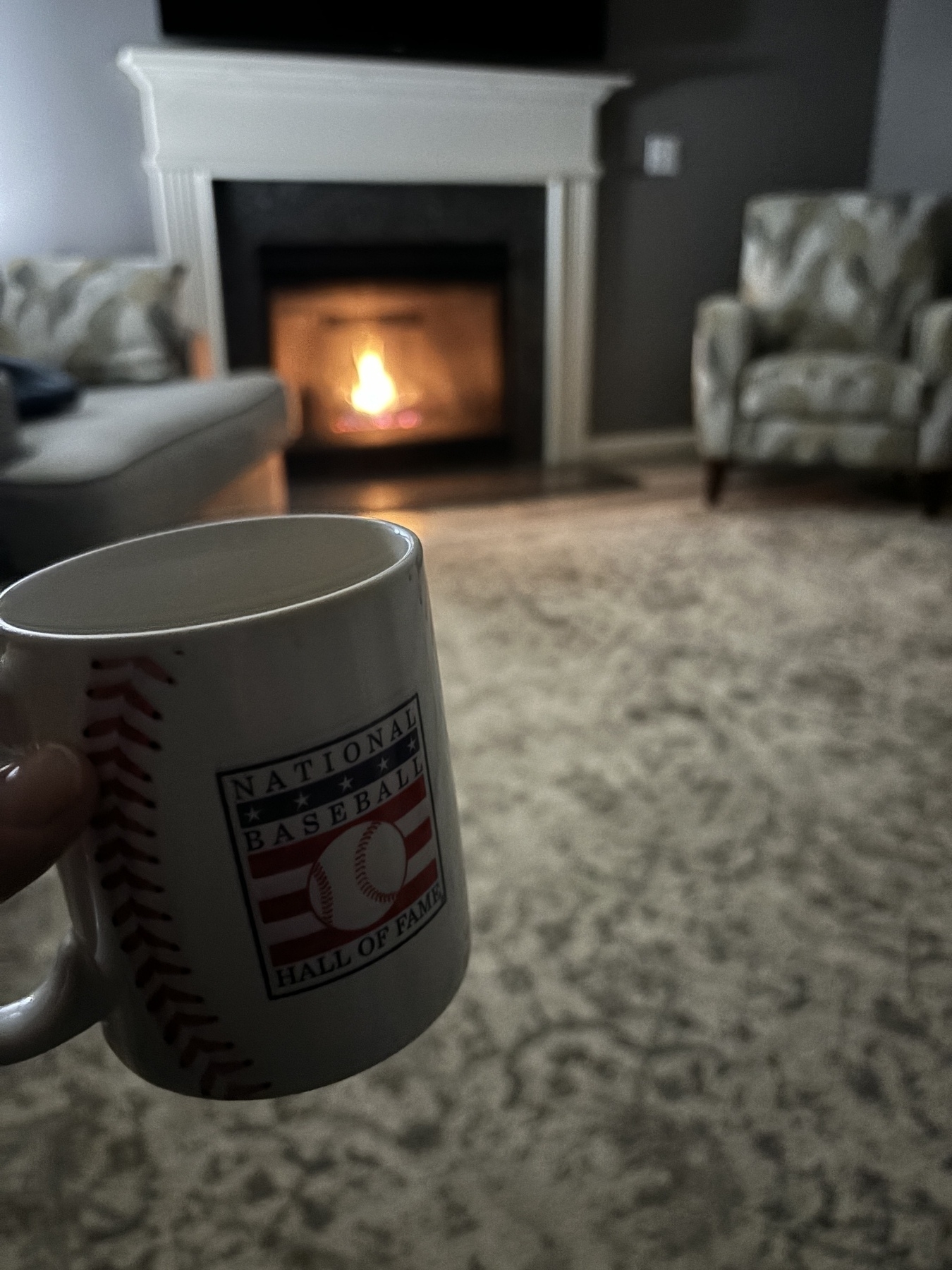 Coffee mug that reads, “National Baseball Hall of Fame” in front of an inviting fireplace. 