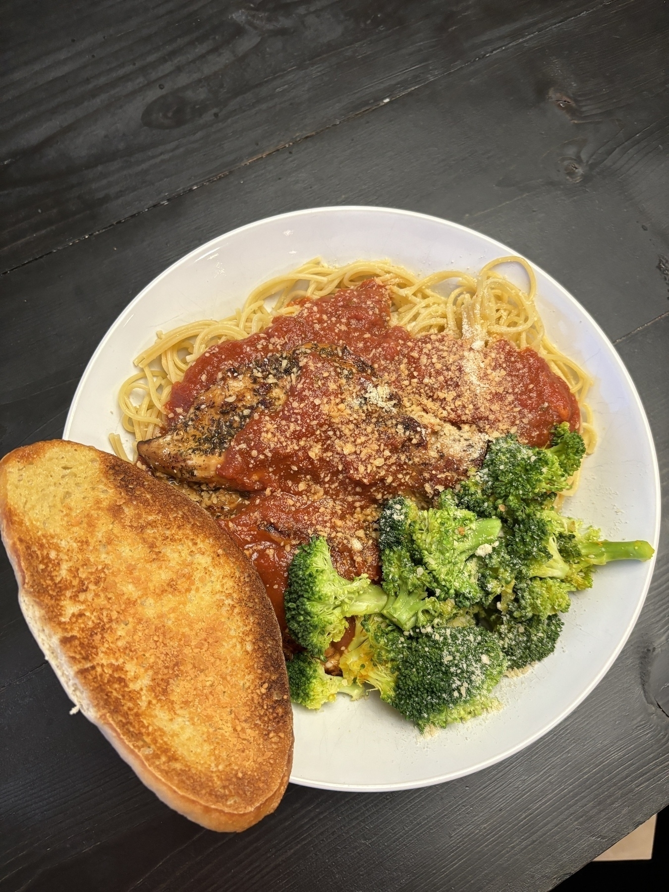 Garlic toast, steamed broccoli, pan friend chicken seasoned with Italian seasoning and balsamic vinegar, on a bed of protein pasta with tomato basil sauce. 