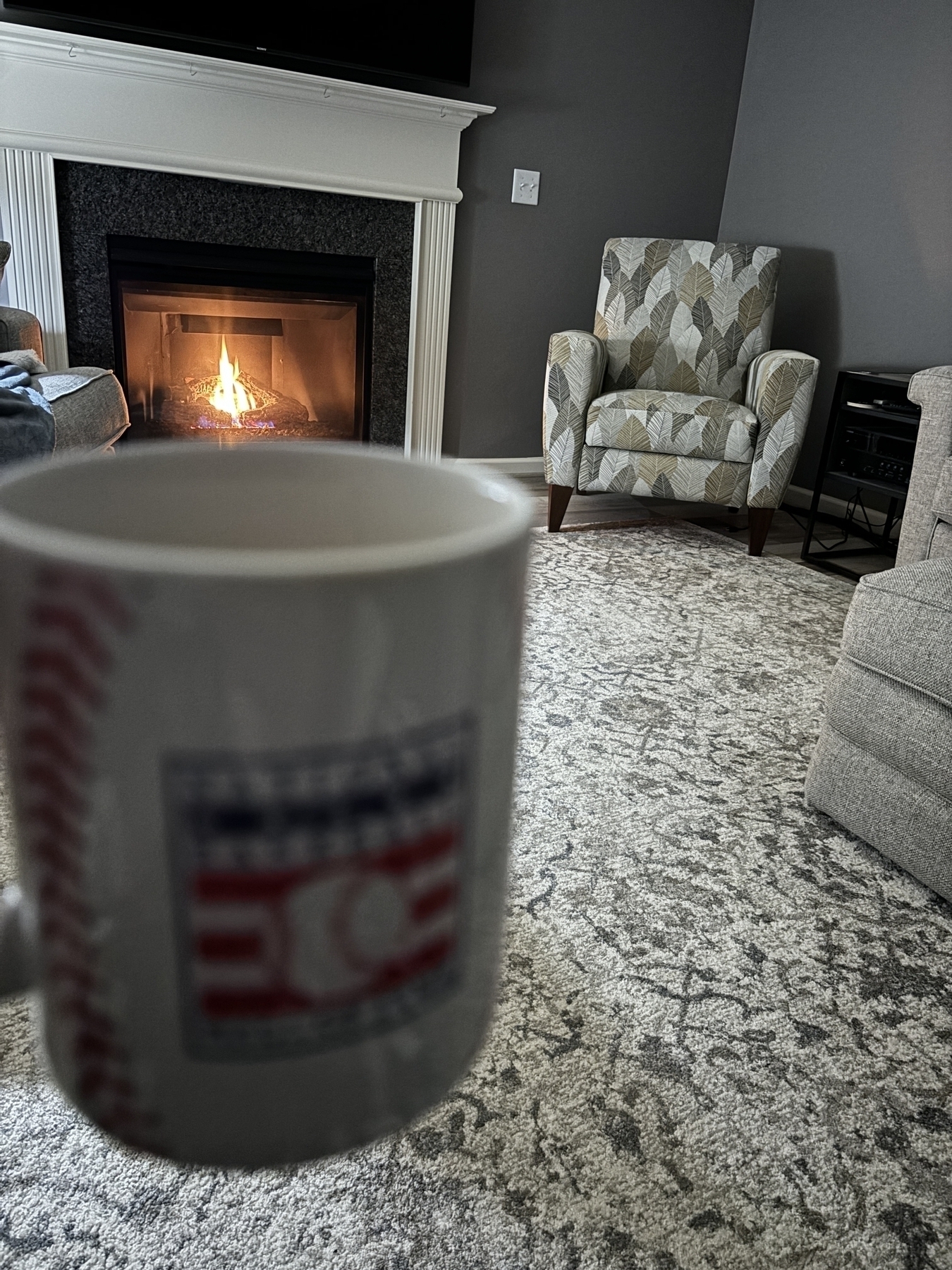 Coffee mug that says “national baseball hall of fame “ in front of an inviting fire 