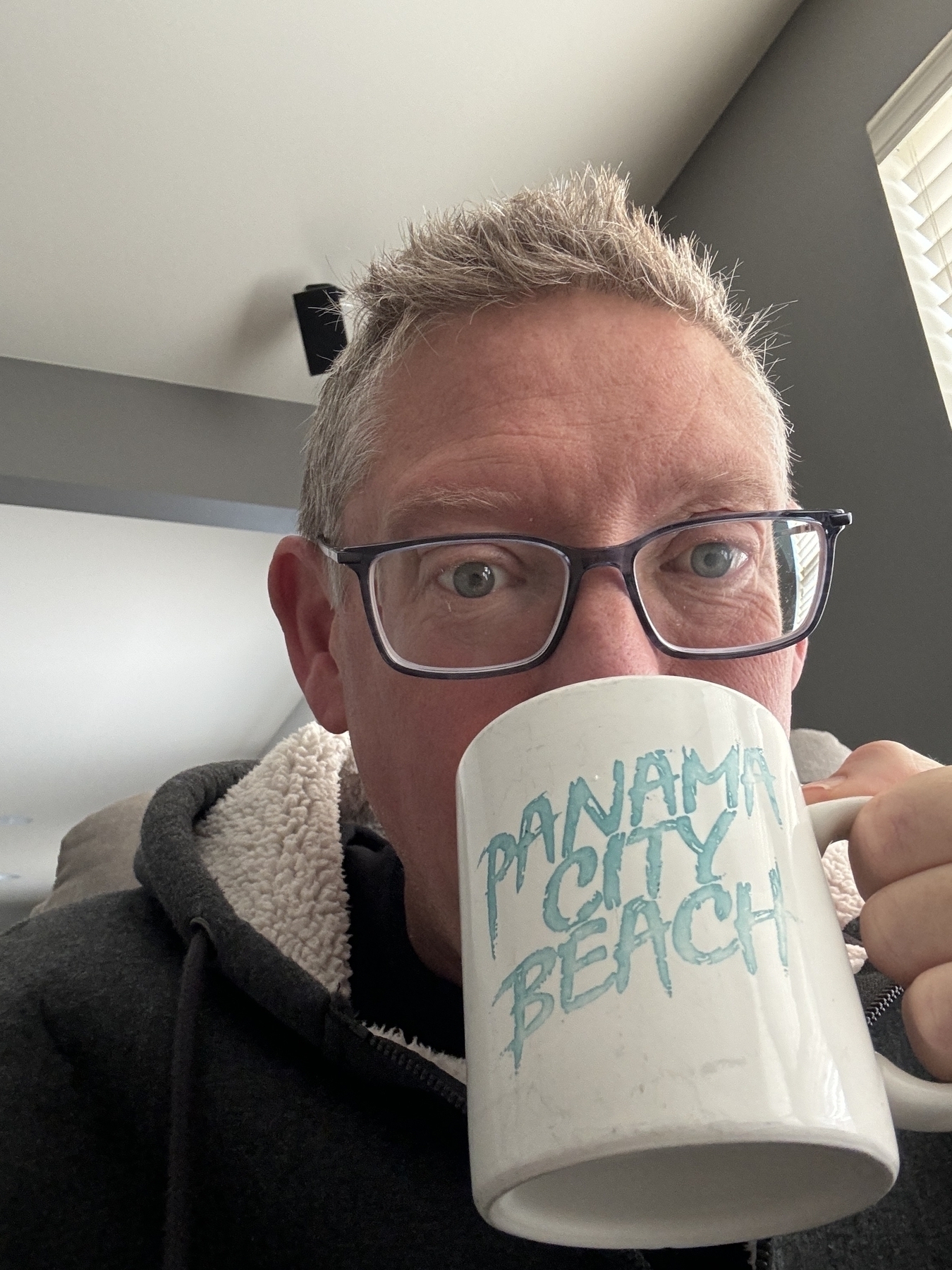 Some guy sipping from a Panama City Beach coffee mug. 