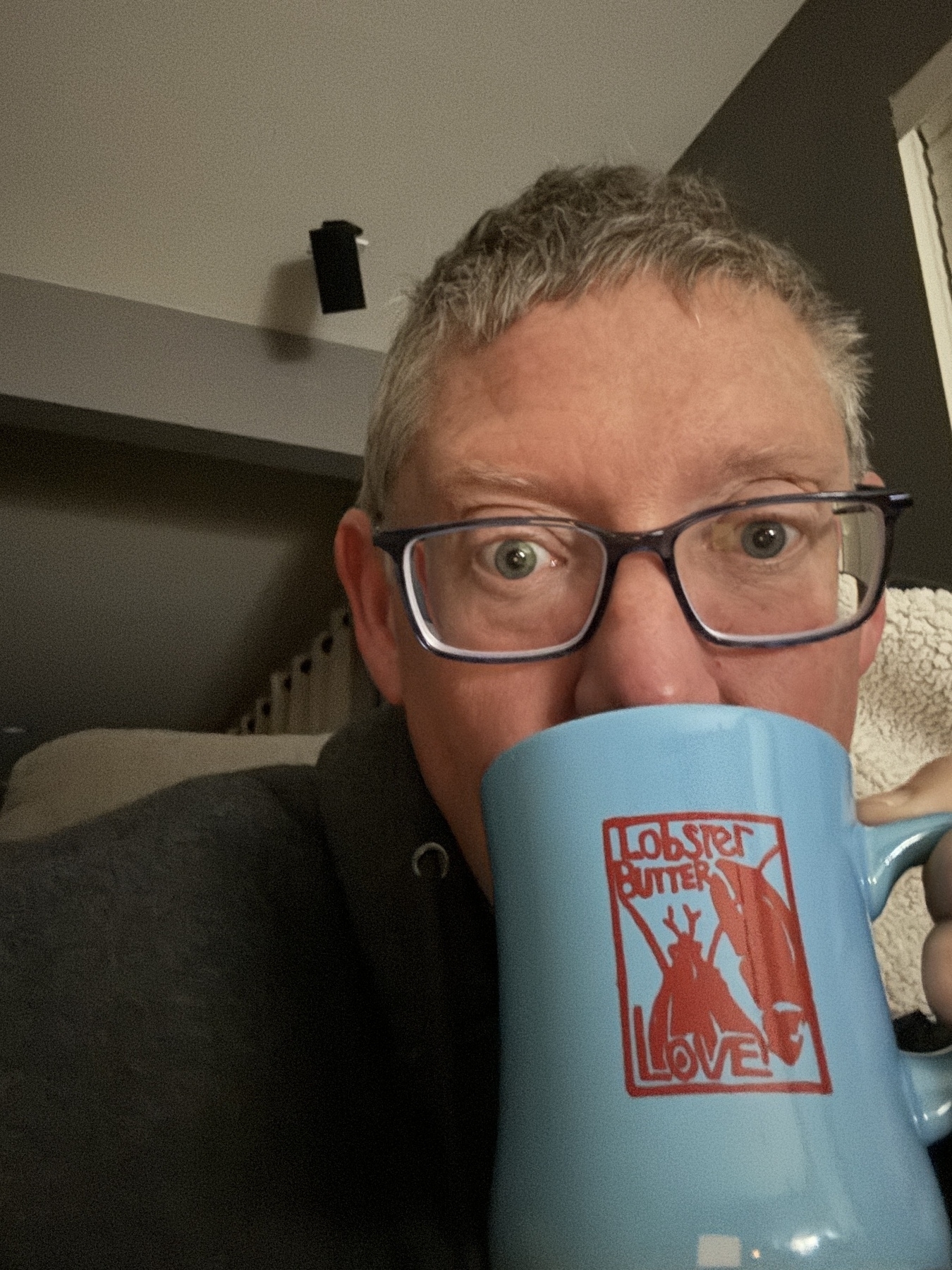 A middle aged fella sipping from a coffee mug 